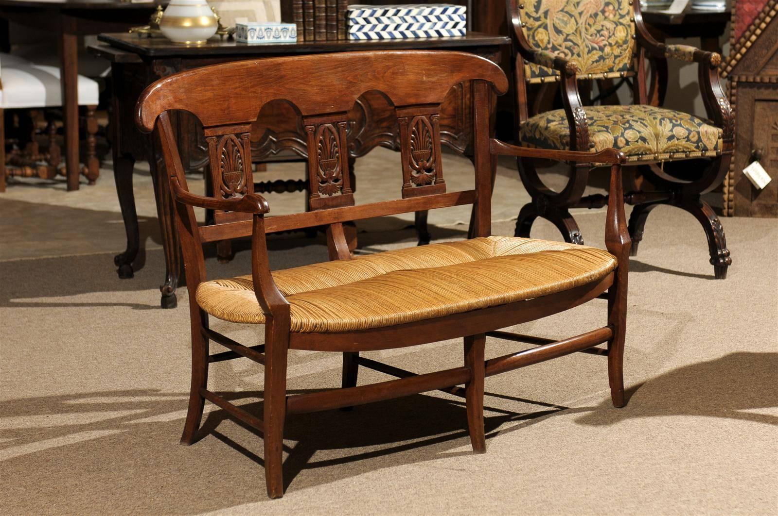 Petite Antique French Bench in Beech, circa 1900
This great two-seat French settee or bench is hand-carved in solid beech. The back has three wonderful design details and the shaped arms add to the charm. It has a classic handwoven rush seat that is