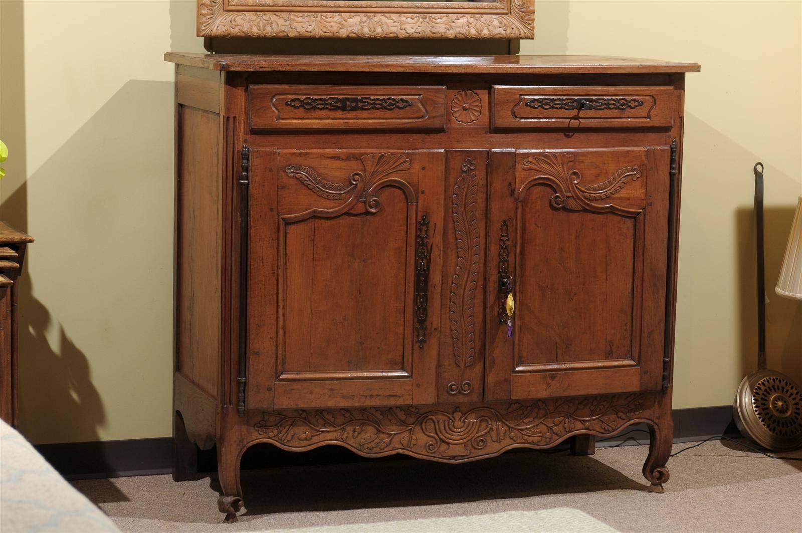 This beautiful buffet has very unusual carvings. We love the carved feathers that adorn the doors and center piece. And the apron has a wandering vine of acorns and leaves. This buffet has a rich patina and a very sought after moderate depth of 22
