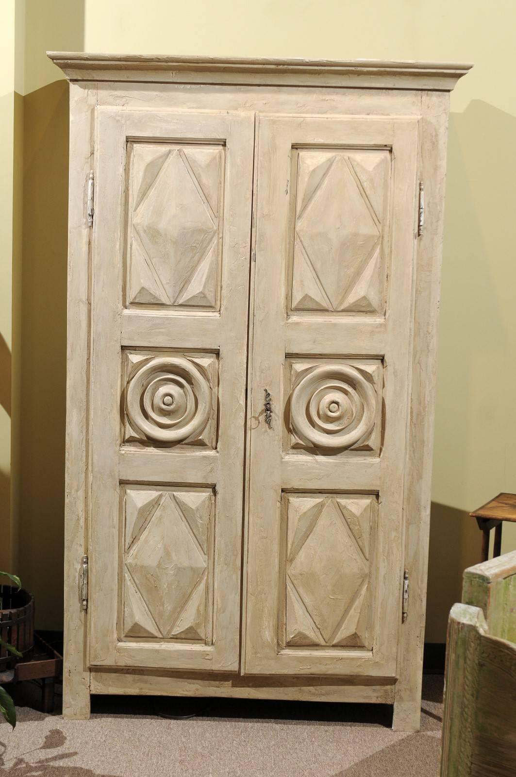 This is a great looking little armoire that has been recently painted. It has a very interesting textured finish which accentuates the angled design and circle pattern on the doors.