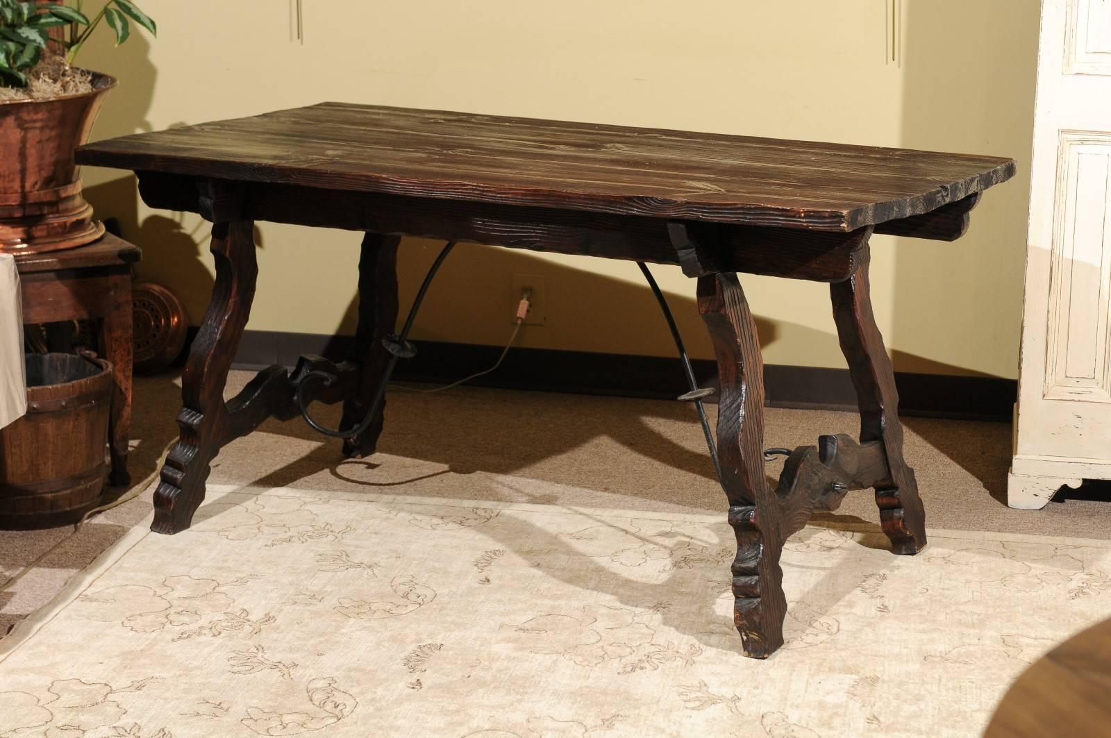 Vintage Spanish style pine table with iron stretcher, circa 1950.
I love the style of this table. It's a little unusual because the top grain is very rough adding to it's charm. The stretcher is the classic style using iron for interest between the
