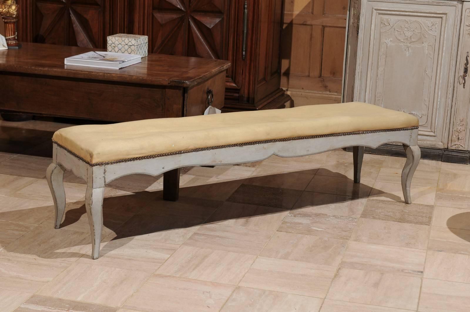 Long benches are difficult to find. This one has cabriole legs and a pretty serpentine apron. The frame has a casual look with some distressing. The upholstery needs to be replaced.