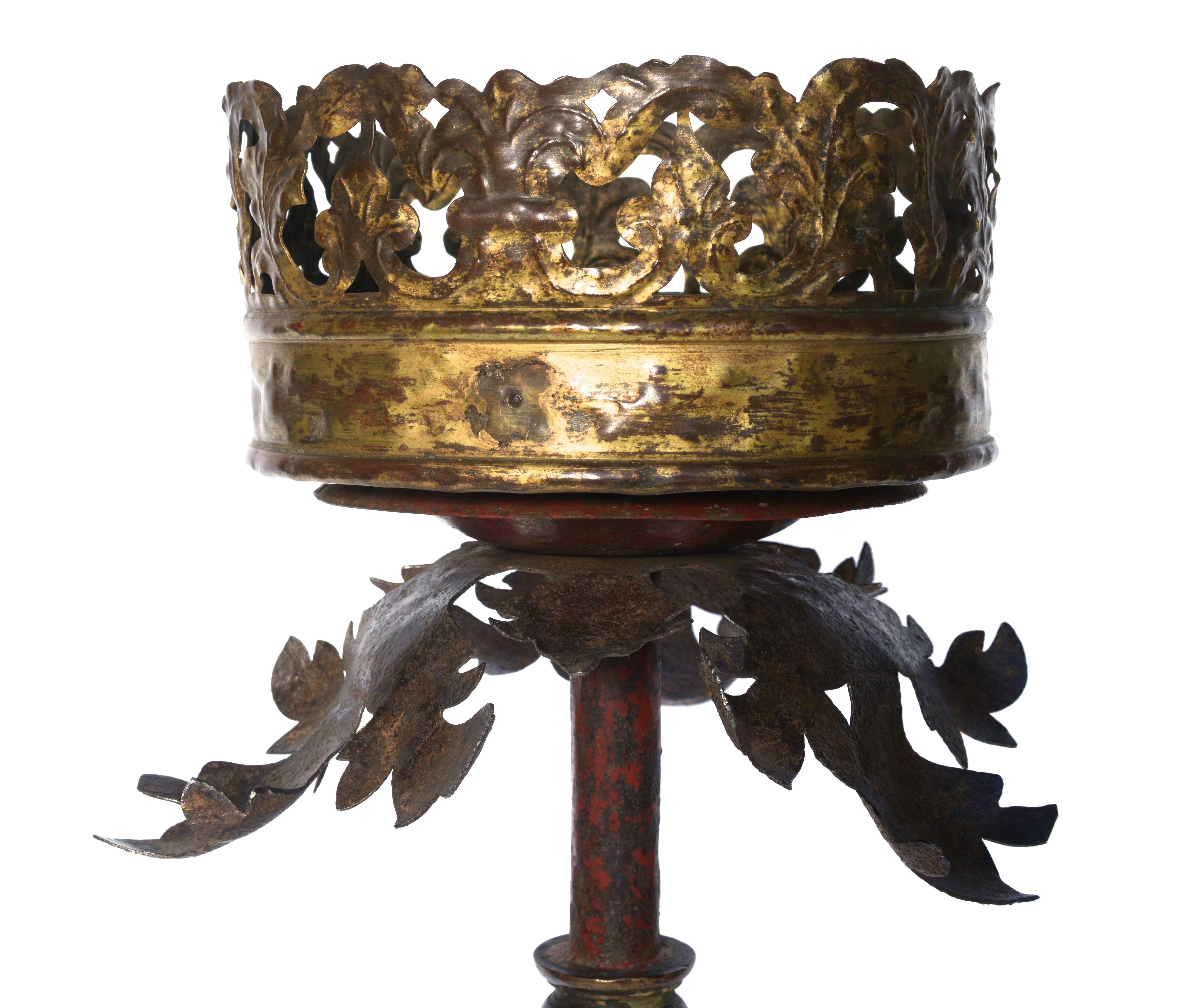 This French torchere has a Fleur de Lis pierced and gilt bobèche that sits on a spray of metal acanthus leaves. It is supported by a red patinated paint column with gilt bronze connectors. The torcher stands on a scrolled tripod base decorated with