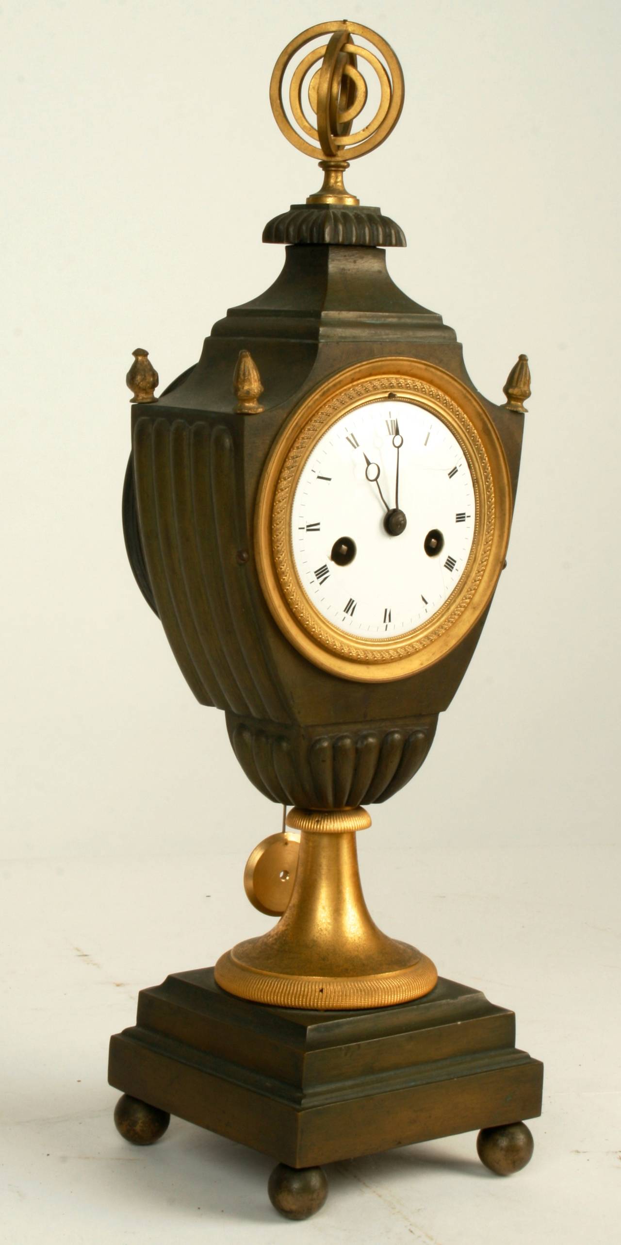 This graceful gilt bronze striking clock is from France’s Directoire period. The clocks white enameled face has black Roman numerals and is framed with a gilt ring in the classical wrapped ribbon design which is typical of the Directoire period