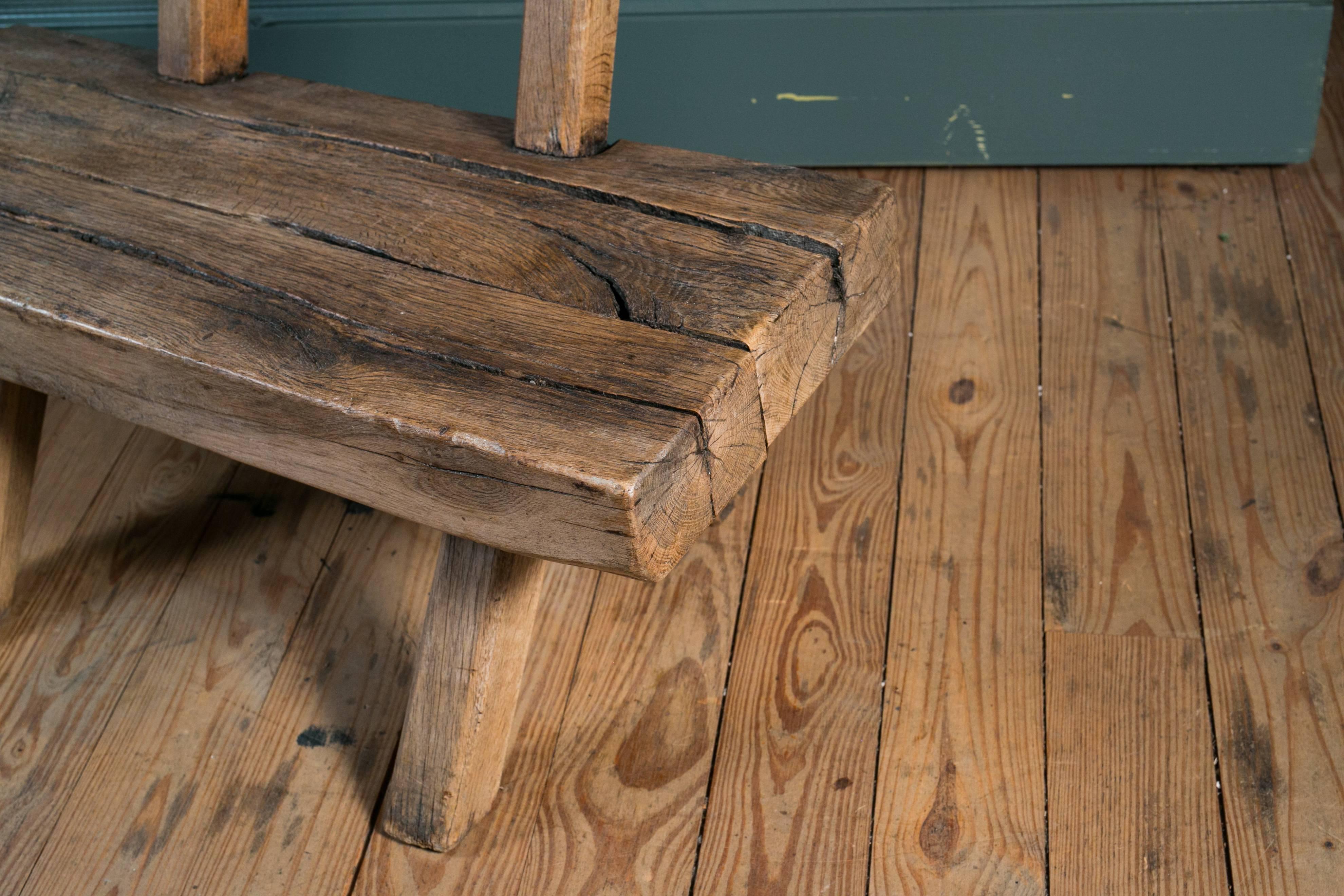 Primitive, handcrafted wooden rustic bench with backrest from Belgium, circa 1920. Sturdy and comfortable. Originally, the bench was used in a bistro near the Belgian/German border. Massive oak construction with iron brackets. Various sizes