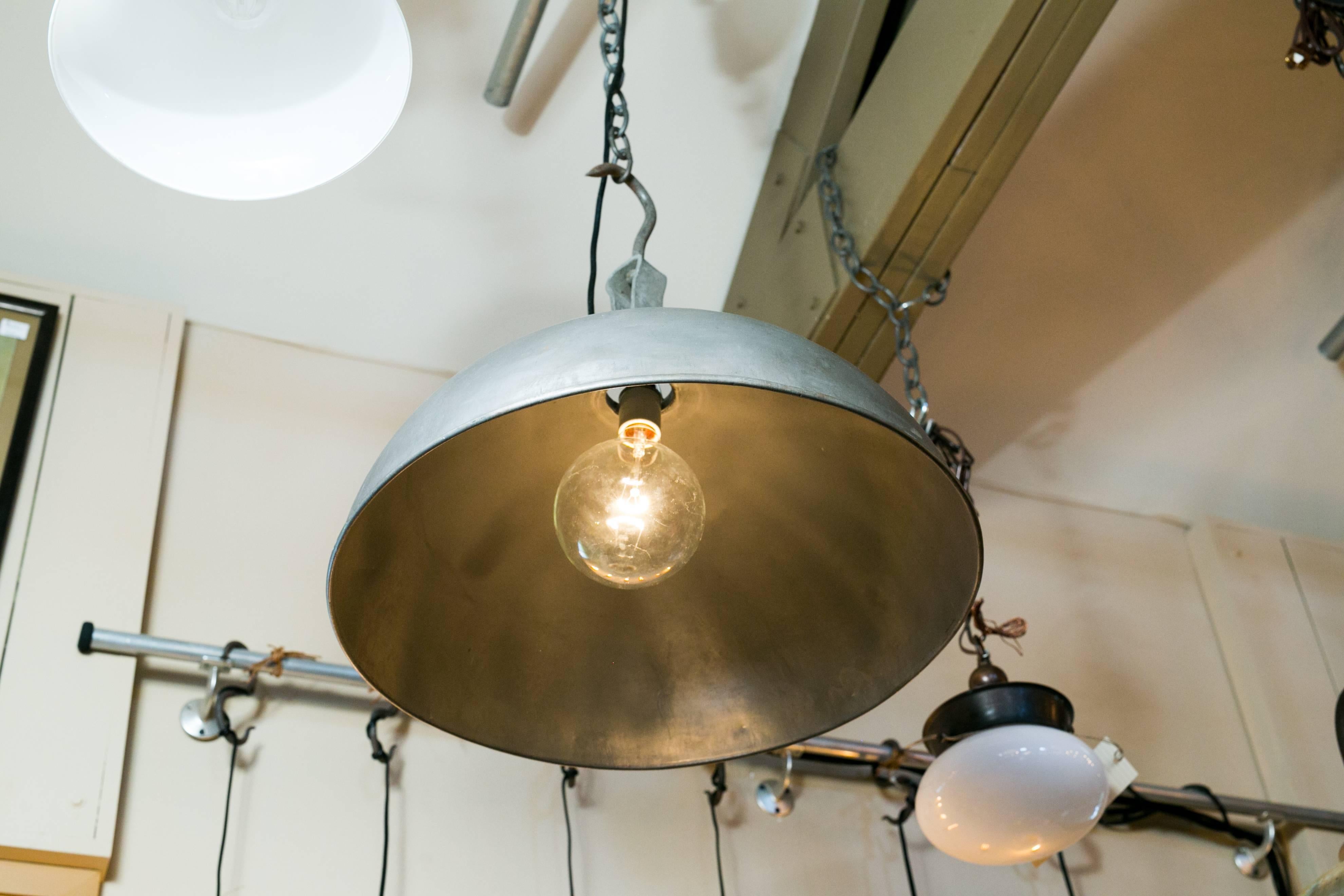 Grey metal dome shaped pendant from Belgium with antique meat hook at top. Newly wired with a single porcelain Edison socket. Comes with chain and canopy. Two available, price is for one light.