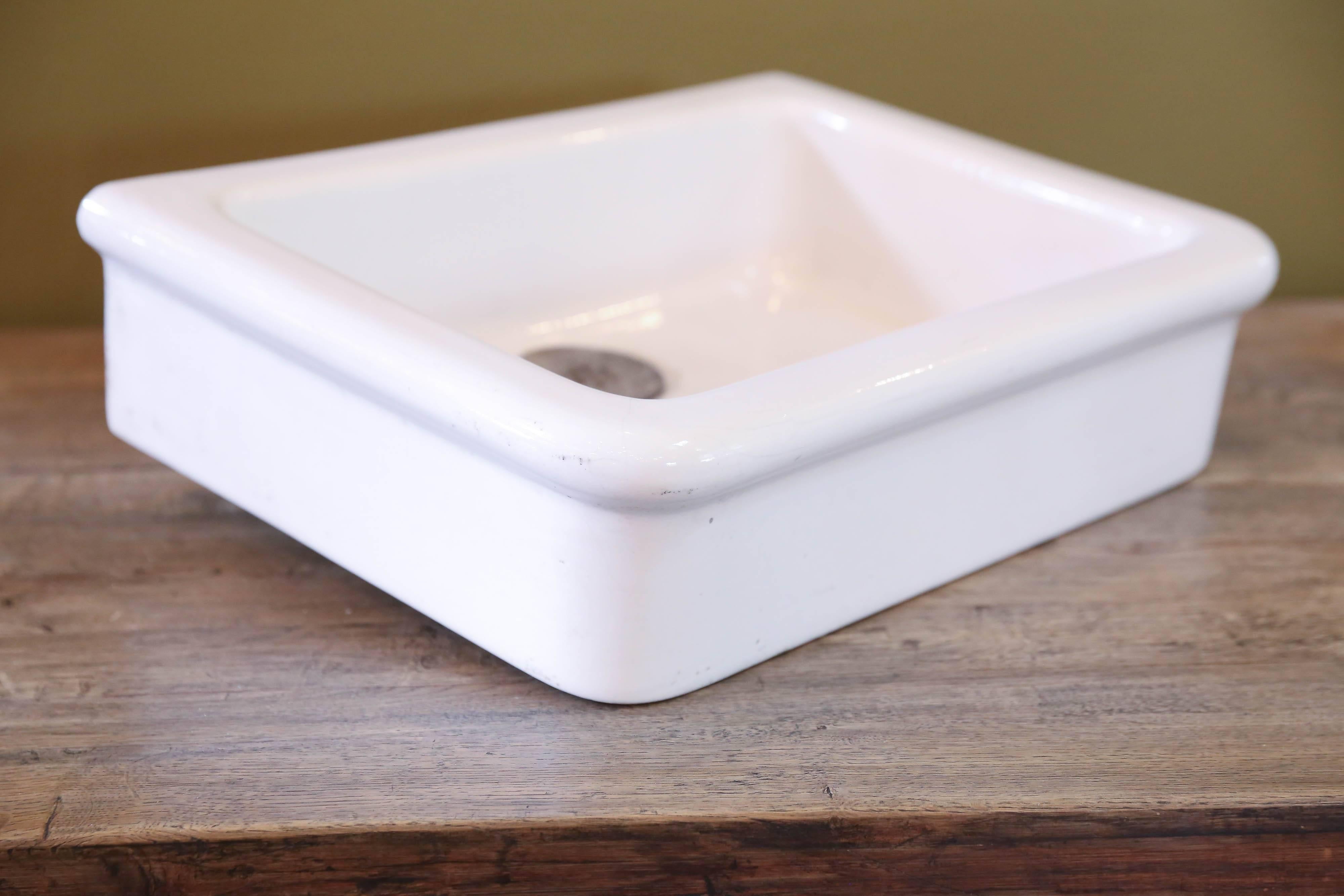 All original, white porcelain sink with metal drainage cover. Farmhouse style with flat back and rounded right angles. From France, circa 1900. Interior depth of sink is 4.5 inches high.