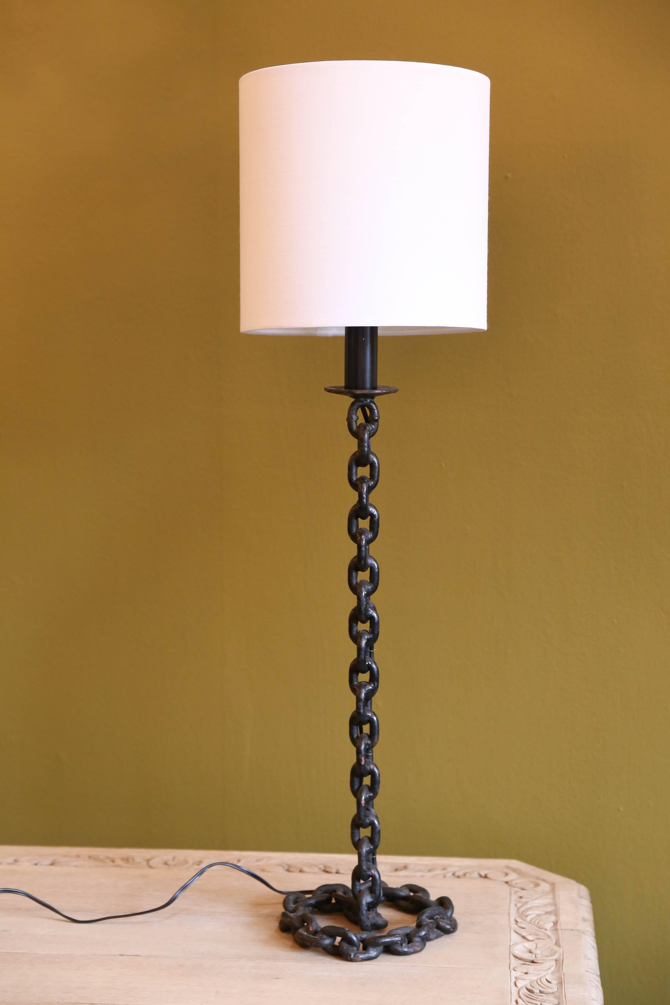 Handcrafted, vintage, painted and soldered iron chain link lamp with fabric shade. Chain coils at the base to make the stand. Newly wired with all UL listed parts and a single Edison socket and black plastic cord. Harp and saddle configuration.