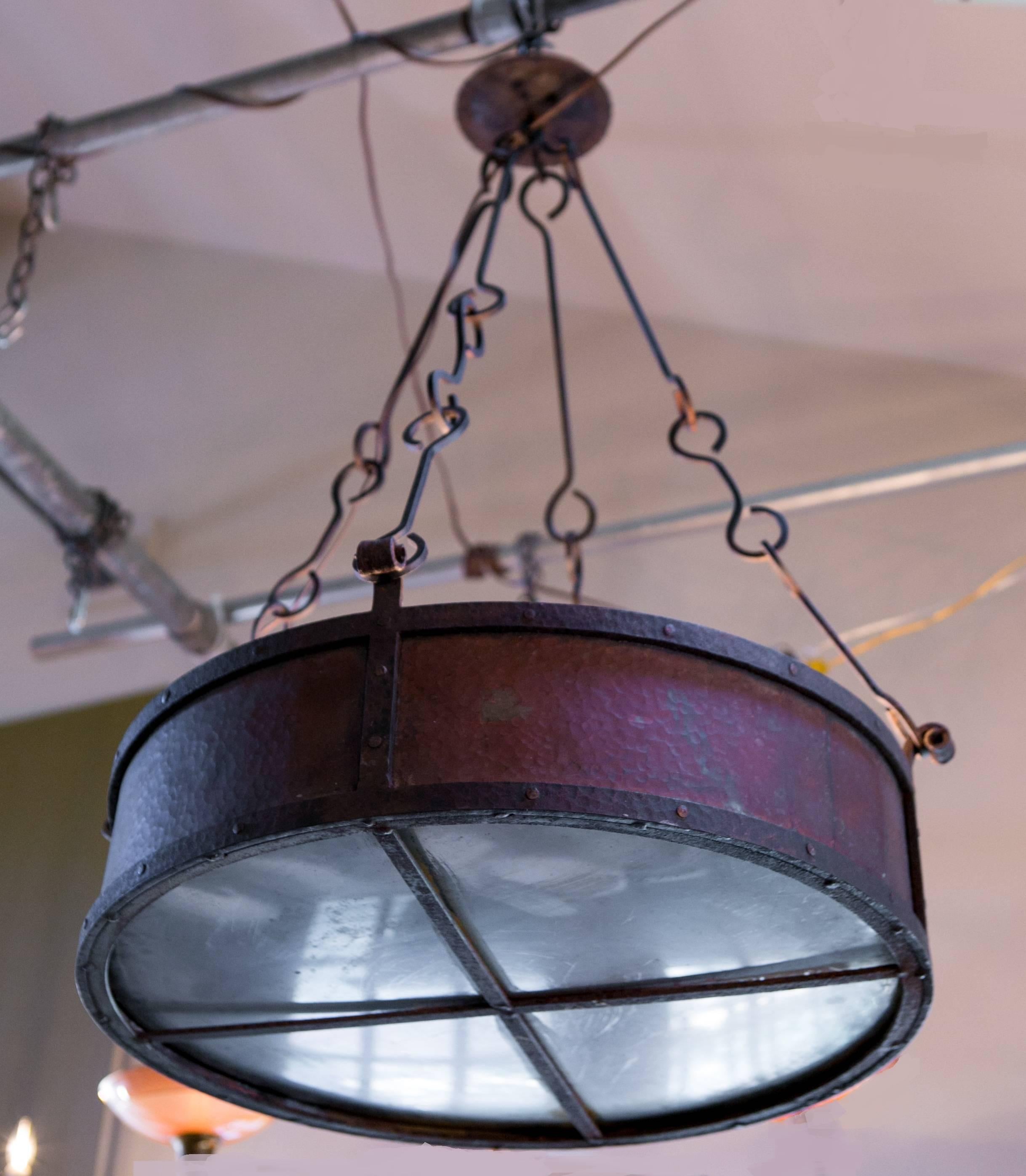 Unusual drum-shaped light with a hammered copper body and hand-forged iron hooks and supports. Metal base shields the bulbs, creating an up-lit effect. Would be great for a wine room. Newly wired with all UL listed parts and four porcelain Edison