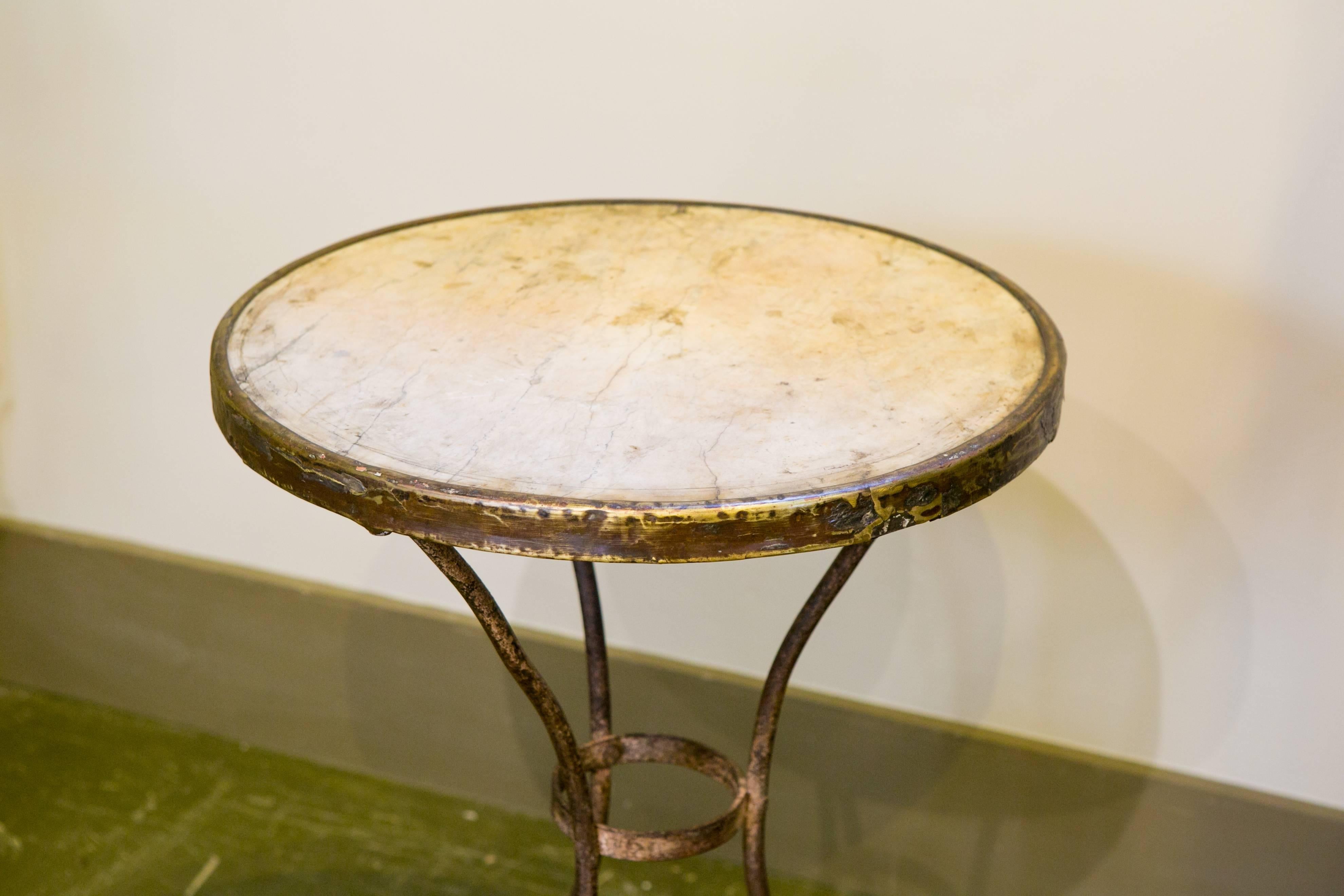 Antique gueridon table with marble top and brass band on an iron base. All original parts. Would make a great bedside table. From France, circa 1910.