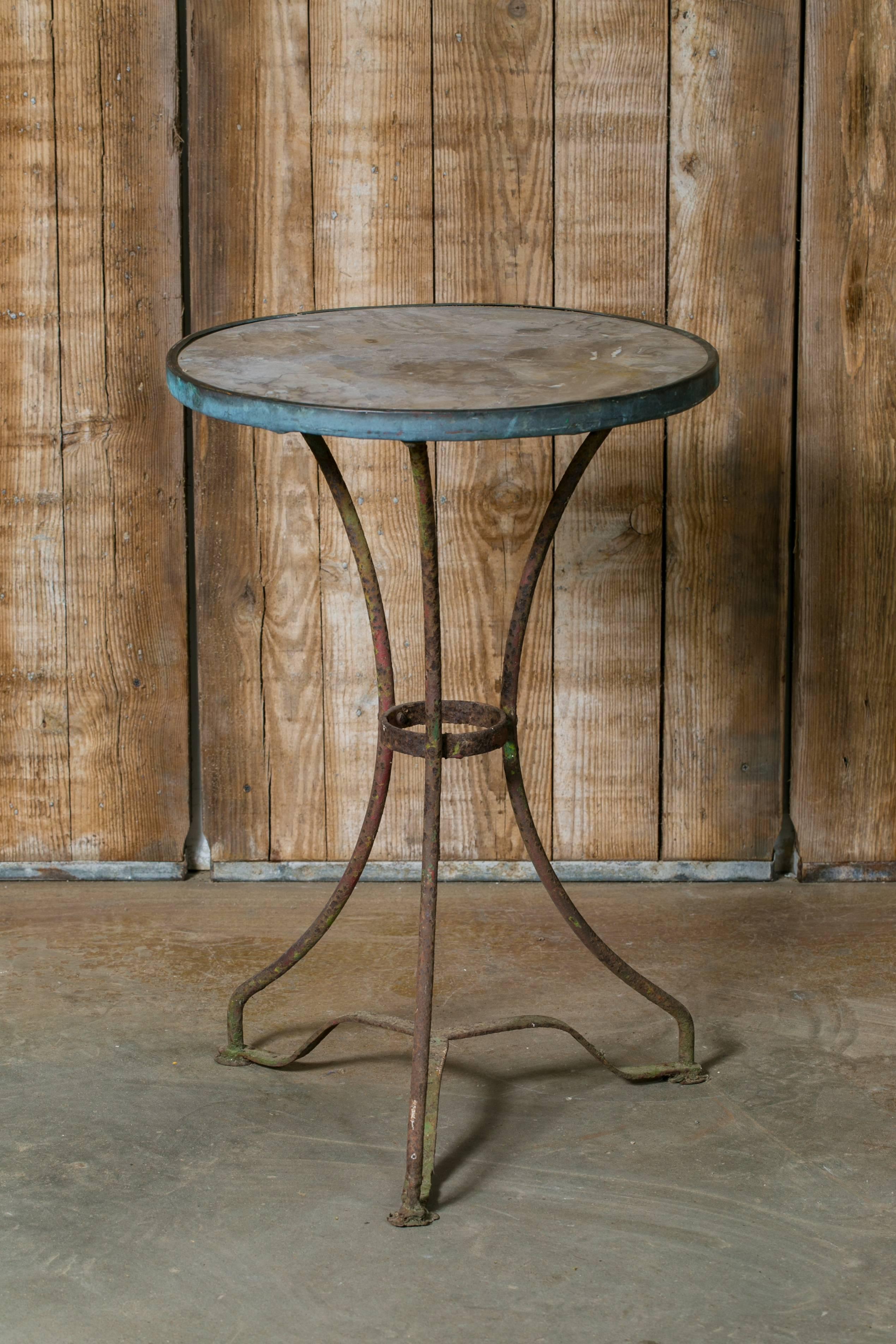 Antique Gueridon table with original marble top, brass band and iron base. From France, circa 1910. Would make a great bedside table. Beautiful verde patina on the brass band with wonderful crusty texture on the iron base.