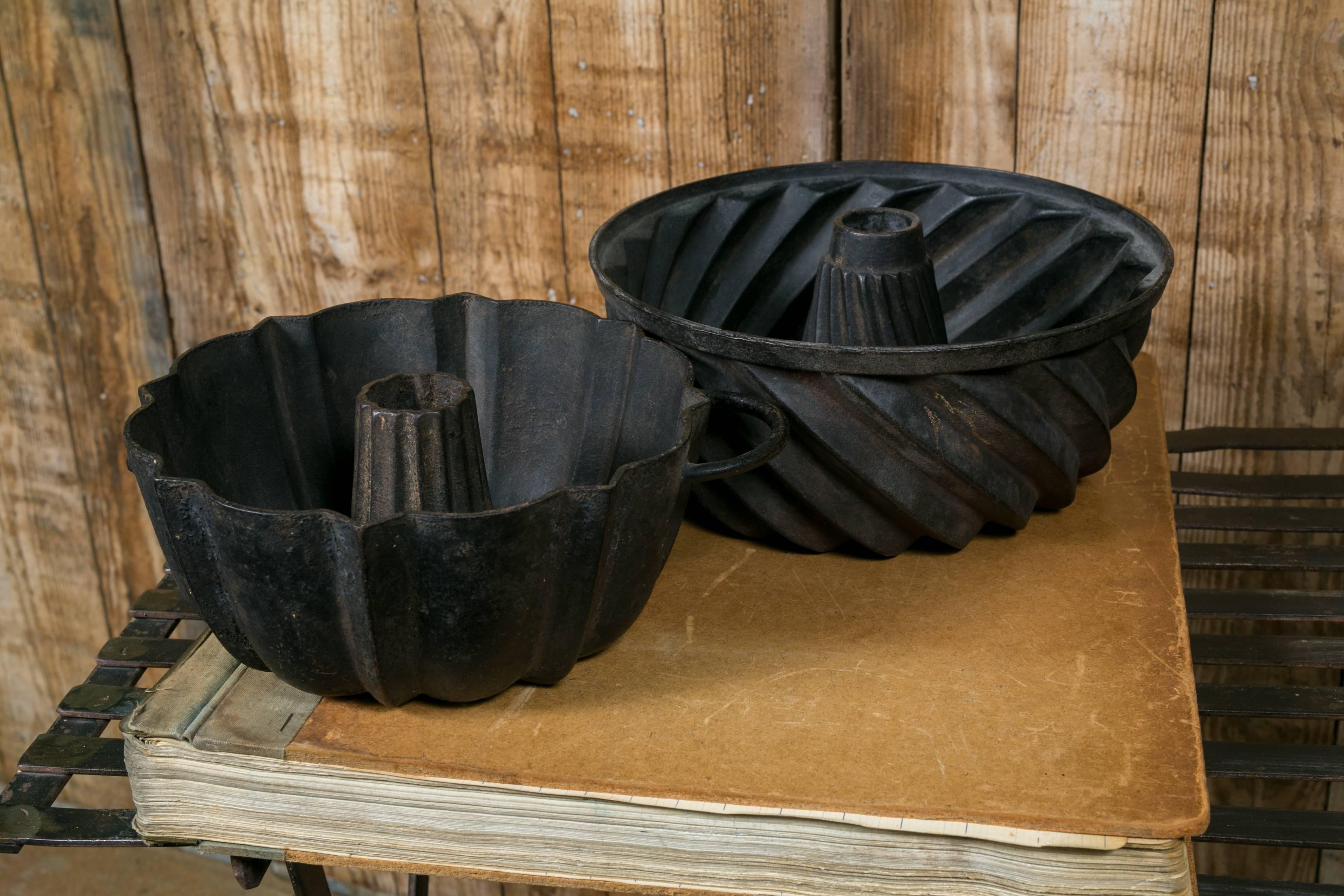 Two antique cast iron traditional Kugelhopf cake pan molds from the Netherlands, circa 1900. One features diagonal ridges and the other vertical. Pan on bottom left has a handle on one side. Price is for two molds. Measurement listed is for mold
