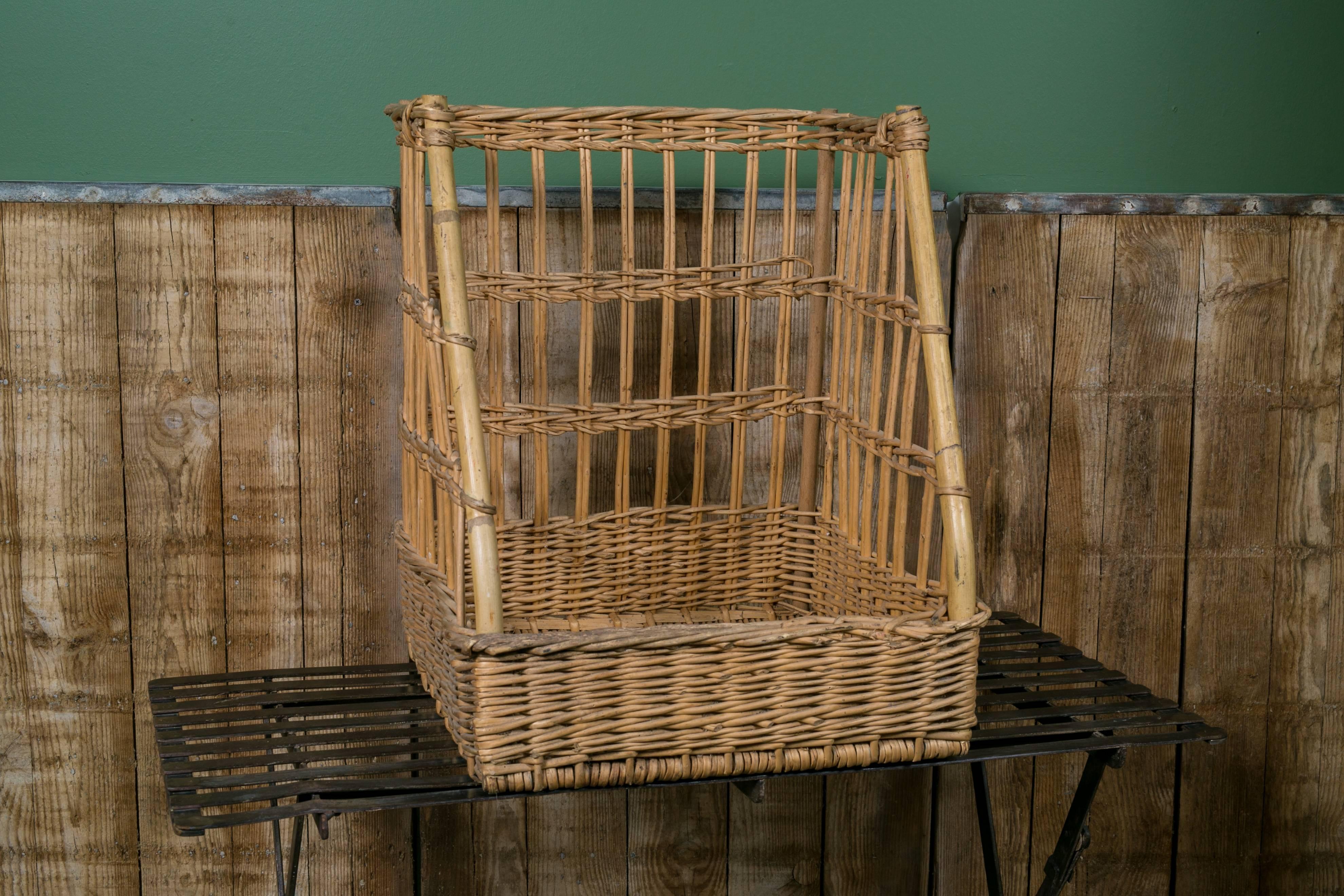 Woven wicker baguette basket used in a French bakery, circa 1960s. Front of basket has bamboo rods for support with all original parts. Would be great in a kitchen or office as an organizational piece.