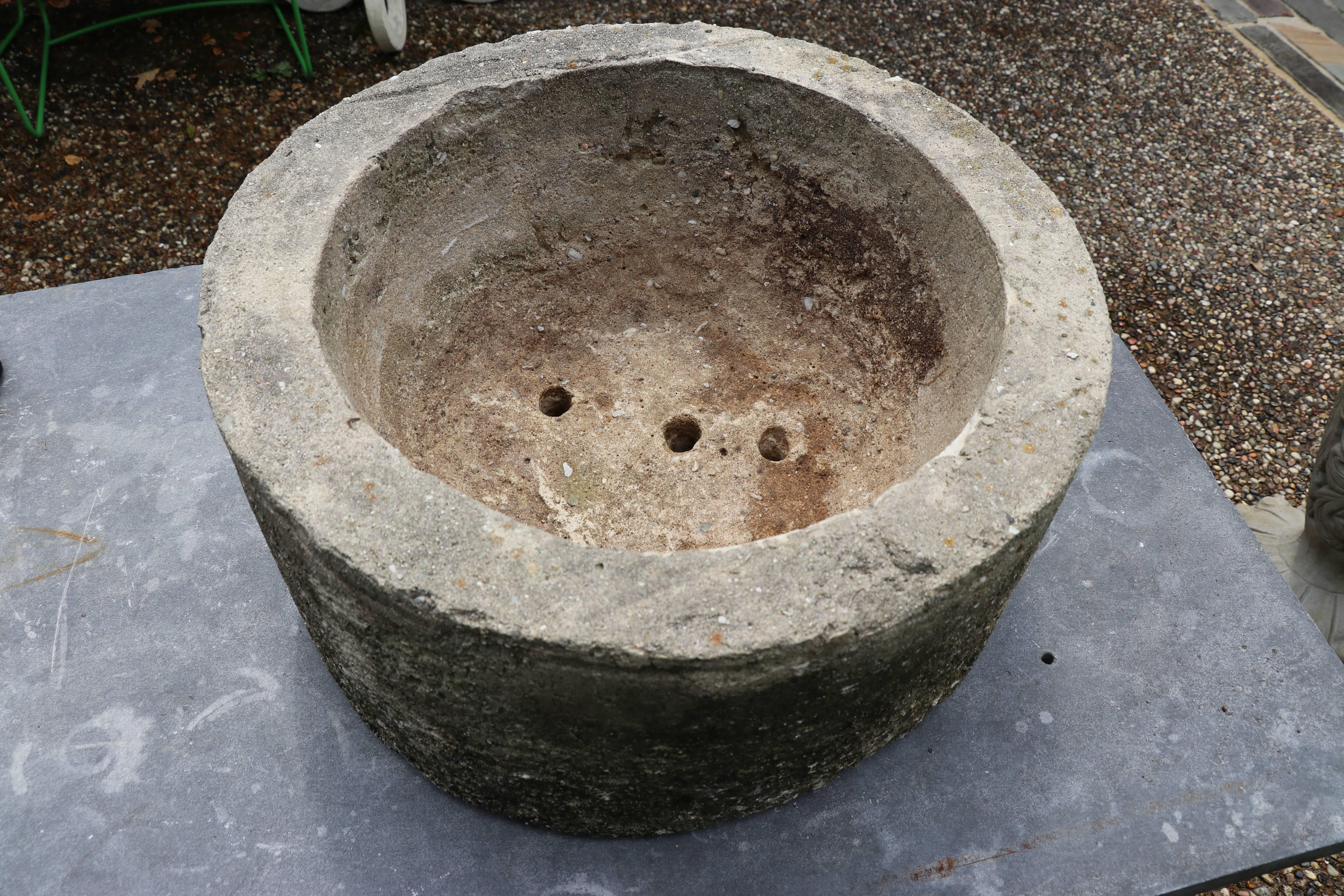 Heavy, round hand-carved Belgian bluestone limestone from Belgium, circa 1900. Features three drainage holes in the base.