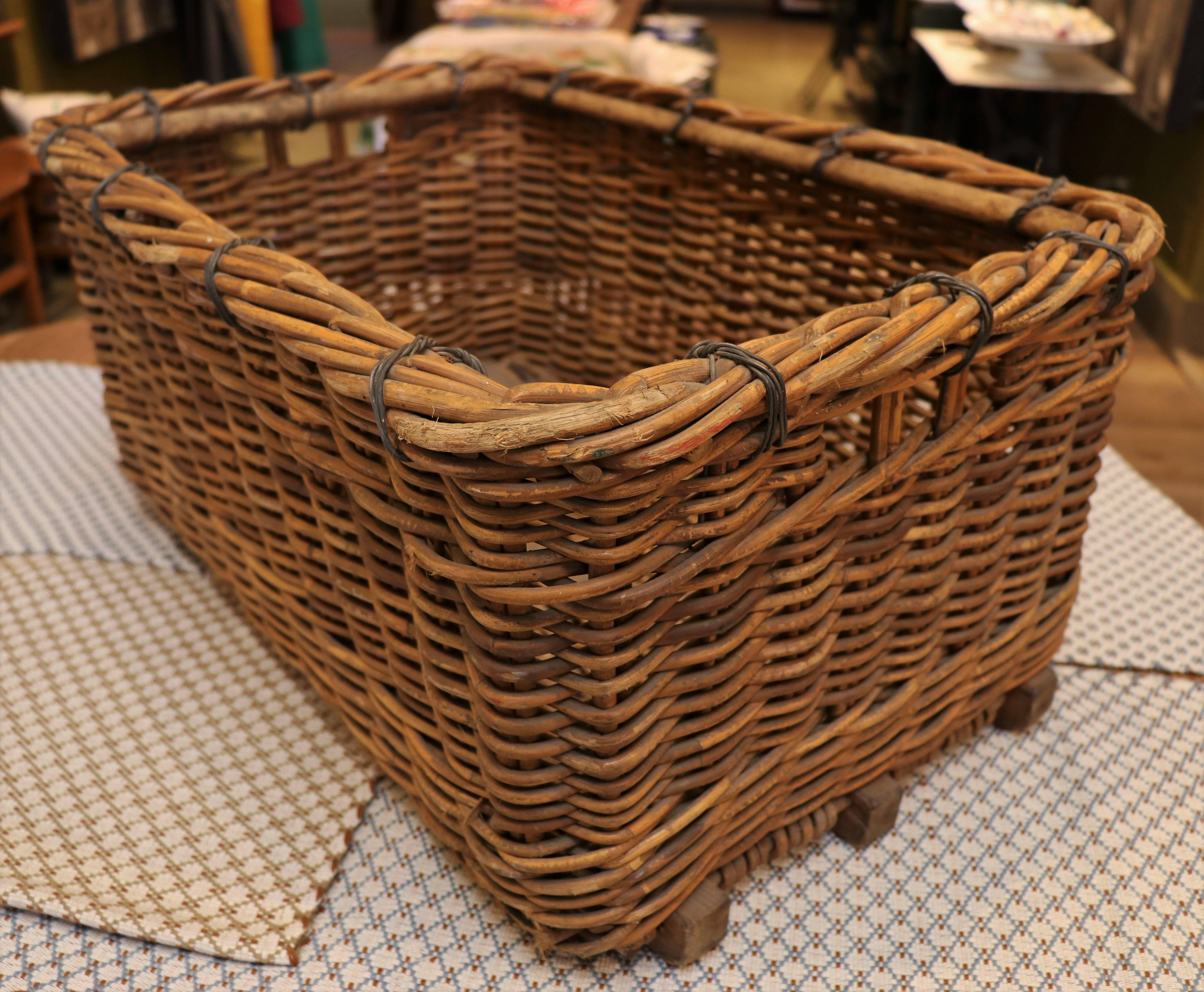 Sturdy and large woven wicker basket from France, circa 1940's. Wire wrapped banding at the top and wood strip supports on the base. Beautiful color and great size.