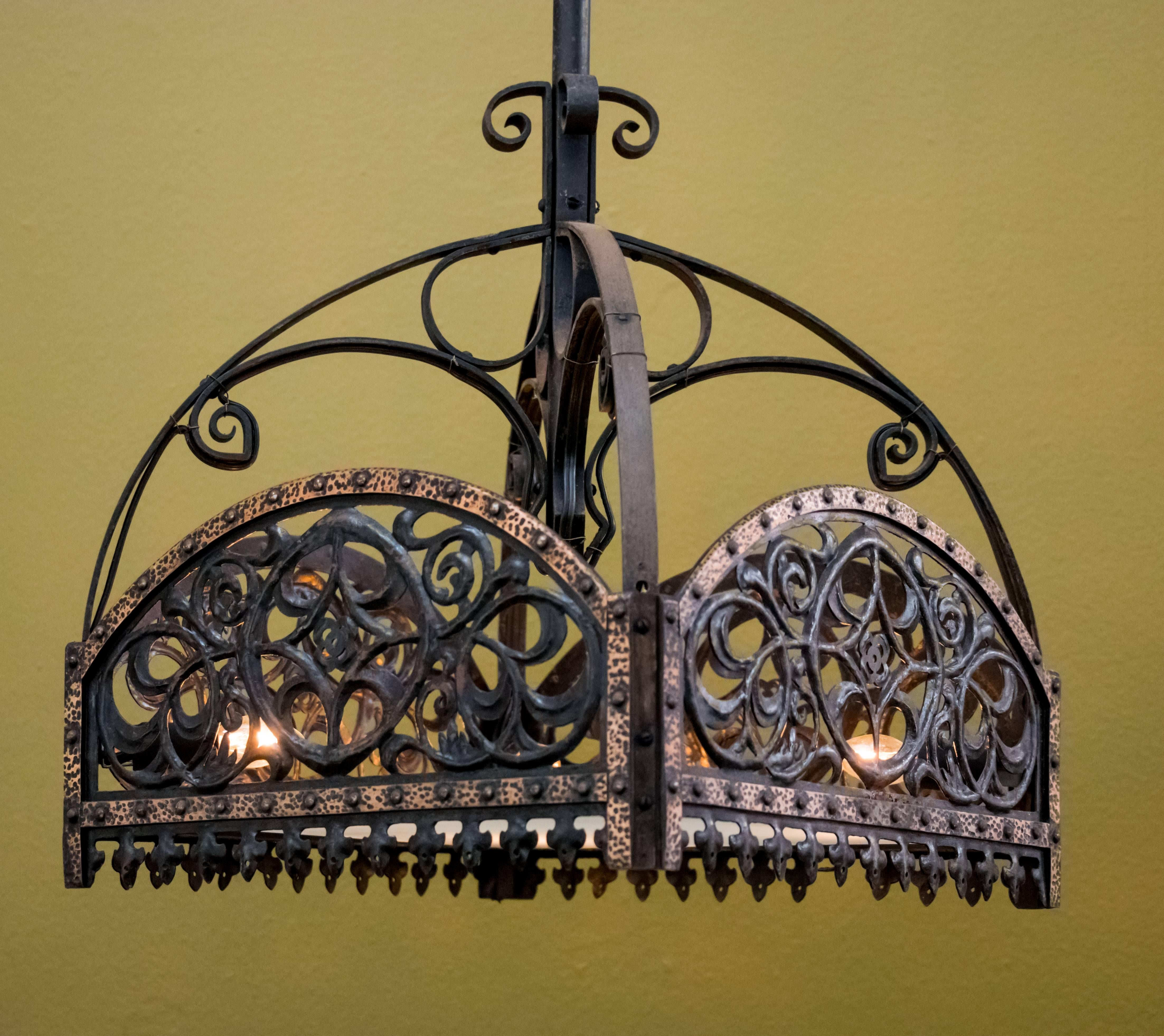 Arts and Crafts / Art Nouveau style light with four internal candelabra sockets. Decorative iron design with hammered copper banding around the top and frosted art glass diffuser at the base. All original parts, excluding the new art glass diffuser