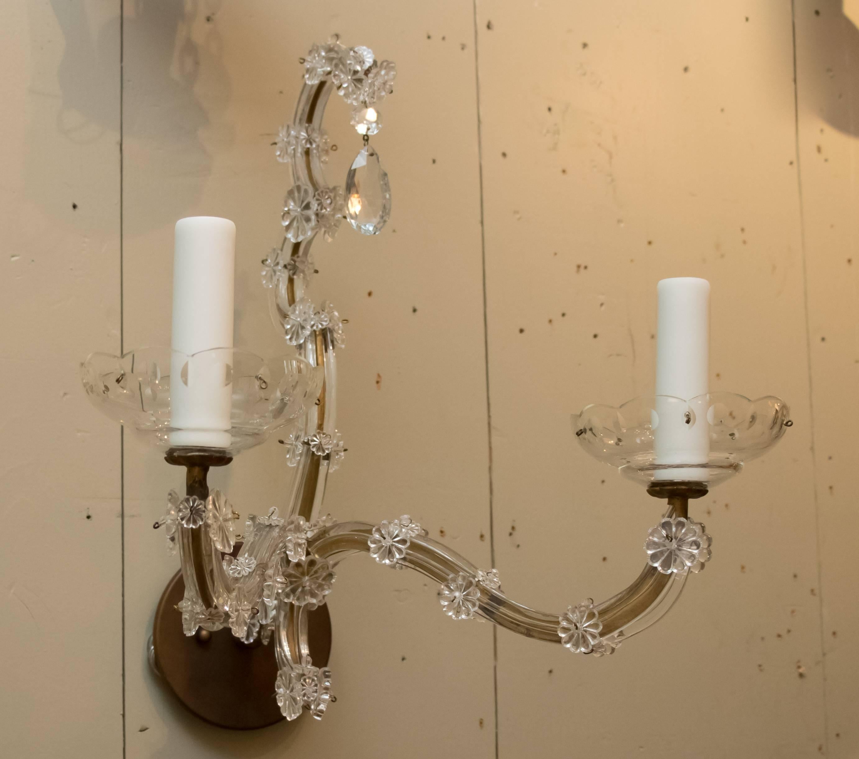 Pair of glass vintage Maria Theresa style sconces from France. Clear flat pieces of glass over an aged brass frame and clear glass rosettes. Pear shaped crystal drop at the top of each sconce with scalloped clear glass bobeche. Newly wired with two