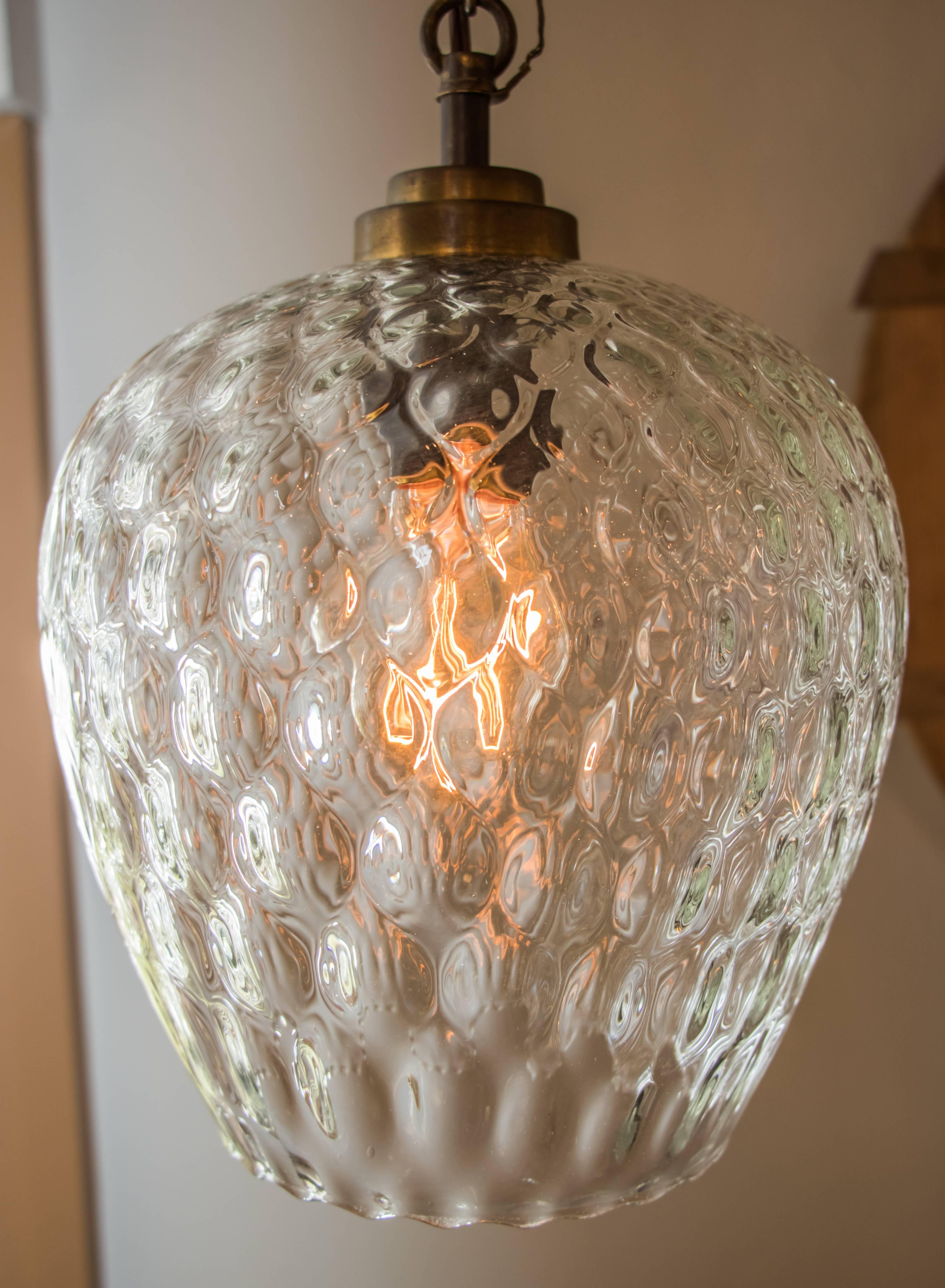 Vintage European handblown glass pendant light. Multifaceted clear glass with a thumbprint pattern that gets smaller as it reaches the top. Newly wired with all UL listed parts and a single downward facing, dark brass covered porcelain Edison