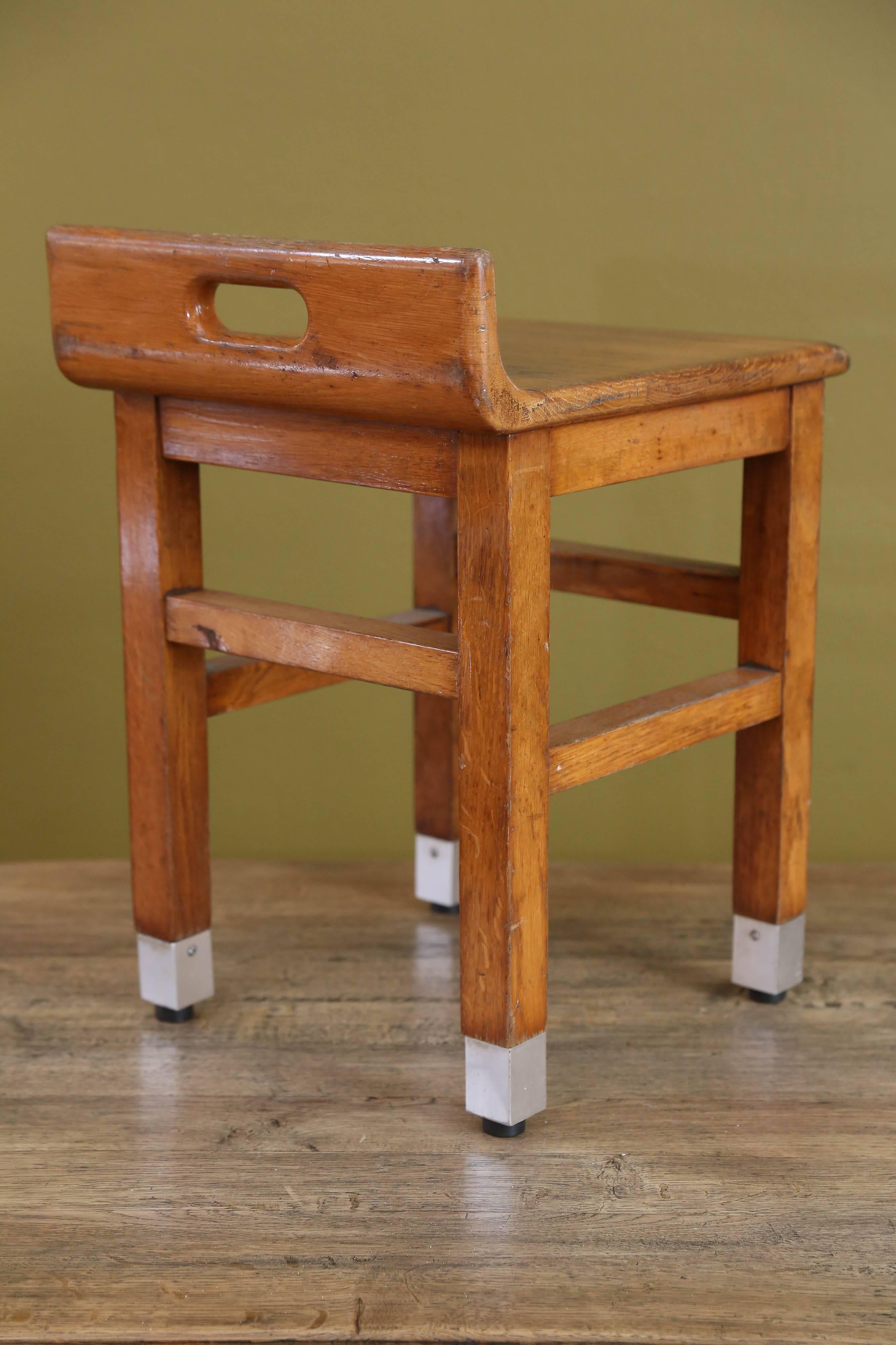 Pair of charming, low-backed Mid-Century Modern oak chairs with metal feet. From Belgium, circa 1960s. Backrests have cut-out handle for easy transport. All original condition with rubber stoppers under the metal and lacquer over the wood. Would