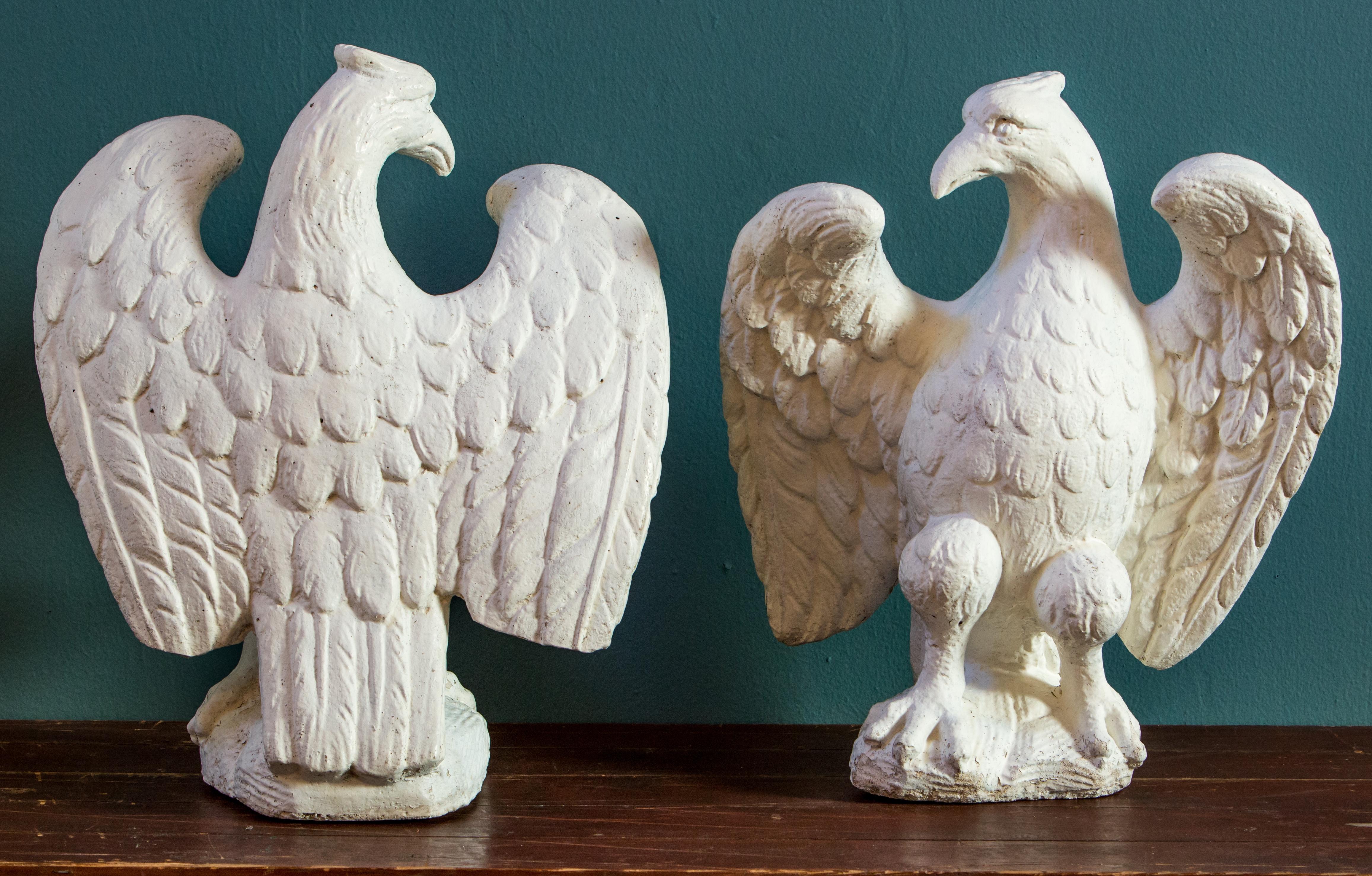 Wonderful pair of Classic eagles cast in concrete. Exceedingly fine detail. Retains old paint and most probably used as finials. The pair of eagles has nice detail. They are appropriate for interior and exterior use and are a bit heavy. Sold