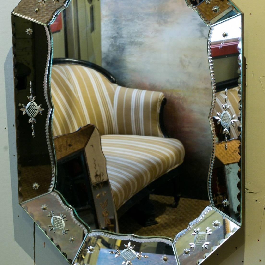 Large Venetian mirror in octagon shape. Frame embellished with etched flower and vine motif, circa 1950s. Silver-toned frame. All original and in excellent condition. Glass is on wood framed back.