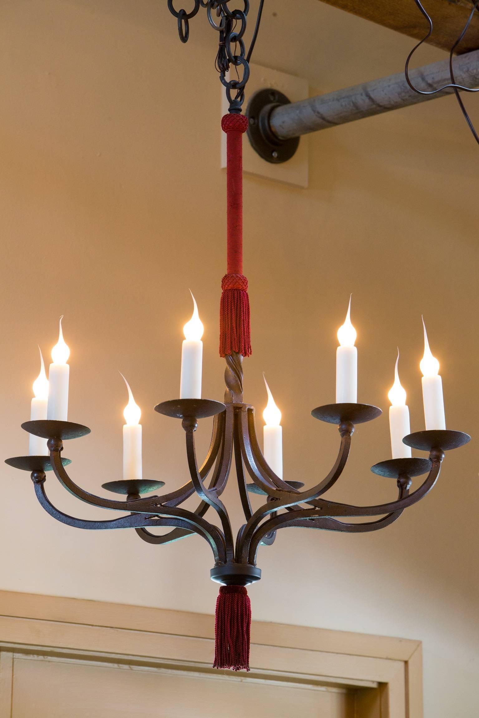 Hand-wrought iron chandeliers from Spain, circa 1940s. All original wrapped cord and tassels. Eight arms per light with candelabra sockets.
Price is for pair. Newly rewired for the U.S. with all UL approved parts. Comes with handmade iron chains