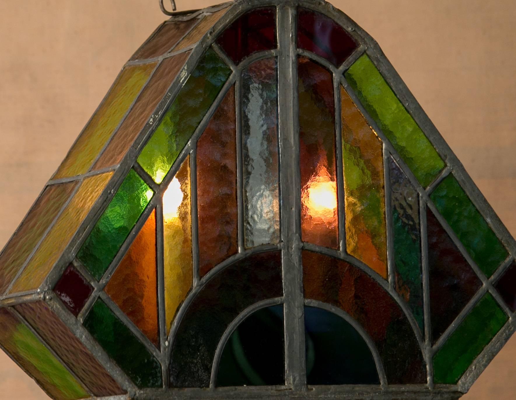 Quirky and charming multicolored stained glass, lead-seamed, triangular lantern from Holland, circa 1920. Newly re-wired for the USA with all UL-listed parts. handcrafted and colorful. Moody tone and light ambiance produced by the stained glass