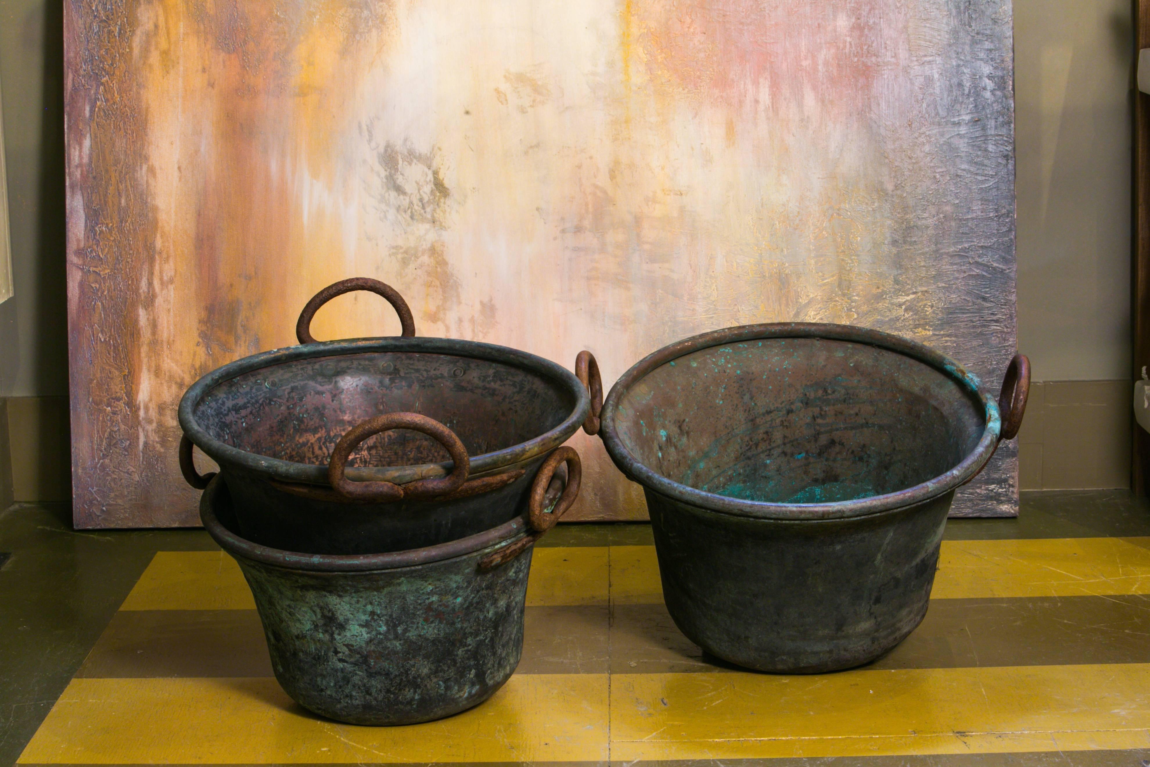 Hand-forged copper antique buckets with round iron handles. Two available in this style and two others with bail handles- all similar in size but one of a kind. Price is for one bucket- your choice. Wonderful patina on the copper. One has more of a