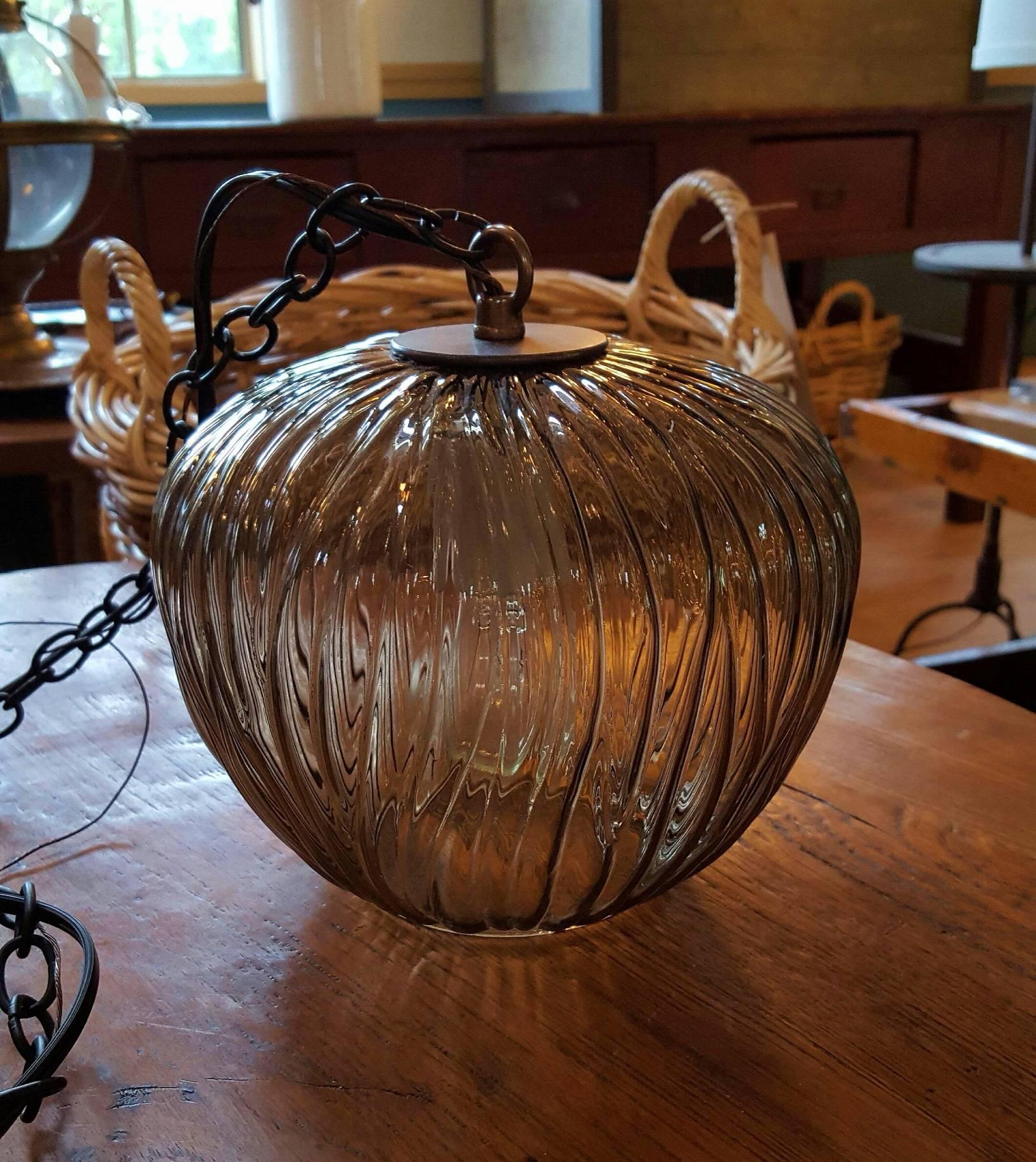 Handblown glass pendant from Italy, circa 1960s. Beautiful smoke grey color with an interesting pattern/texture. It was photographed with a filament bulb which makes the glass look golden. It is actually a brownish-grey color when lit with a clear