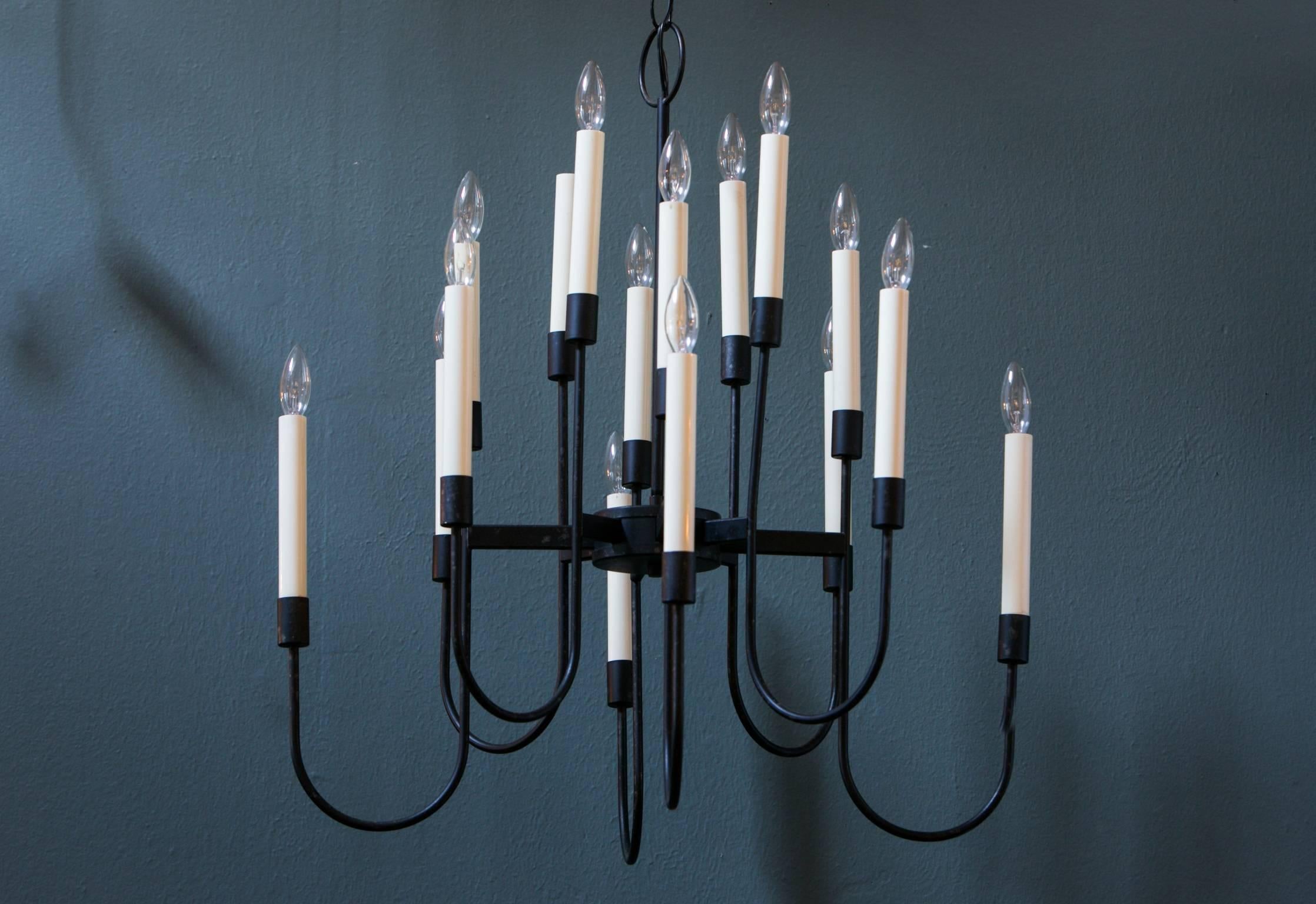 Black Mid-Century 16-arm chandelier by Lightolier. The design is often attributed to Tommi Parzinger. Newly rewired in the USA with all UL approved parts. Eight arms with two lights per arm. Uses chandelier socket bulbs, 60W maximum. Comes with