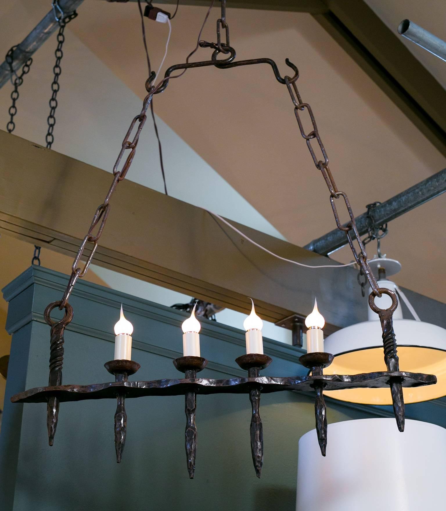 Vintage black and brown wrought iron Brutalist style bar light with four Edison sockets, newly wired in the USA with all UL listed parts. Comes with hand-made long links of iron chain and canopy. From France, circa 1950s.  Center lights are the