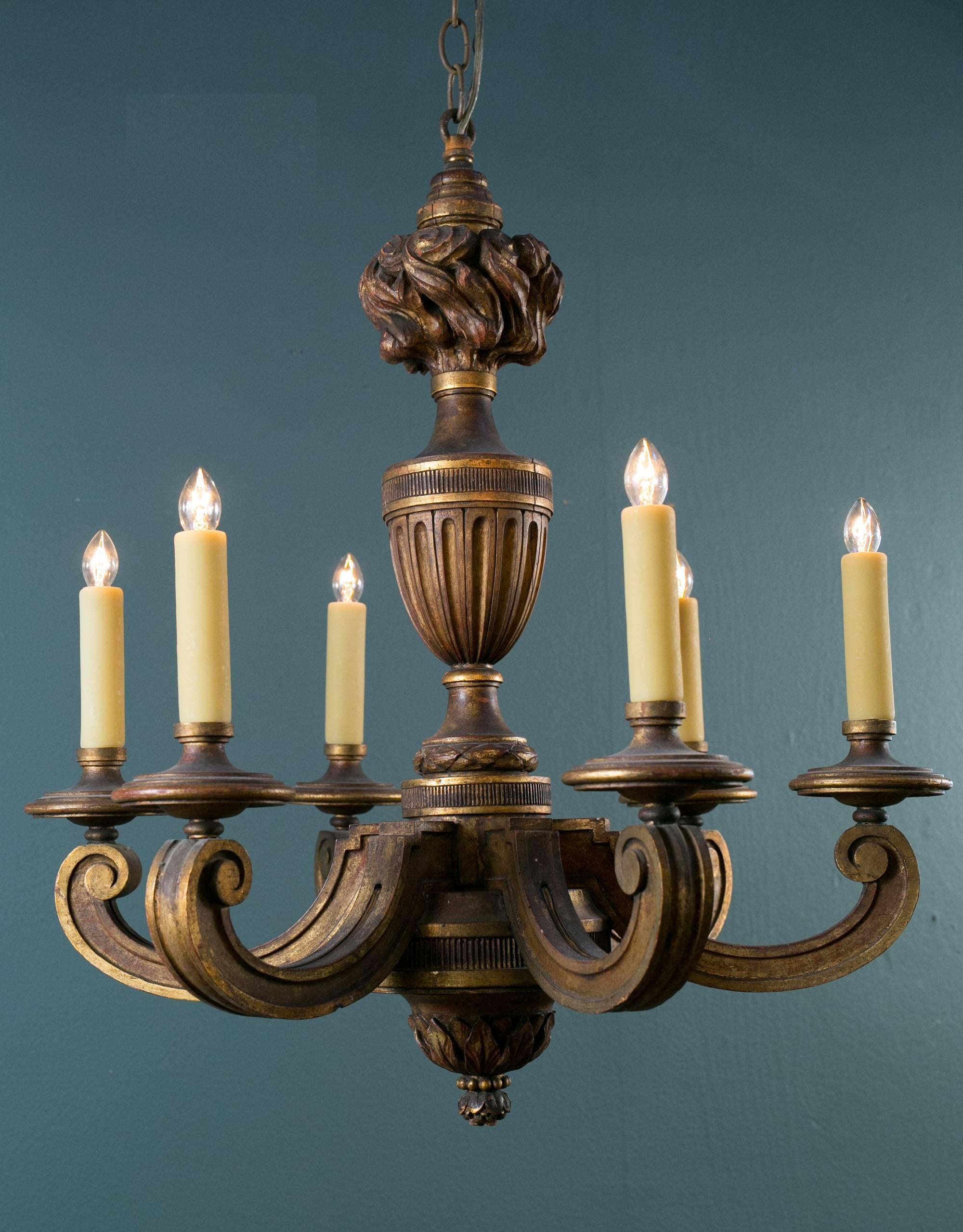 Antique bois dore, carved gilt wood chandelier from France, circa 1890.   Empire in the Neoclassical style.  Masterfully hand-carved with a  torch flame finial at the top and an acorn finial at the base. Six candelabra sockets, newly wired in the