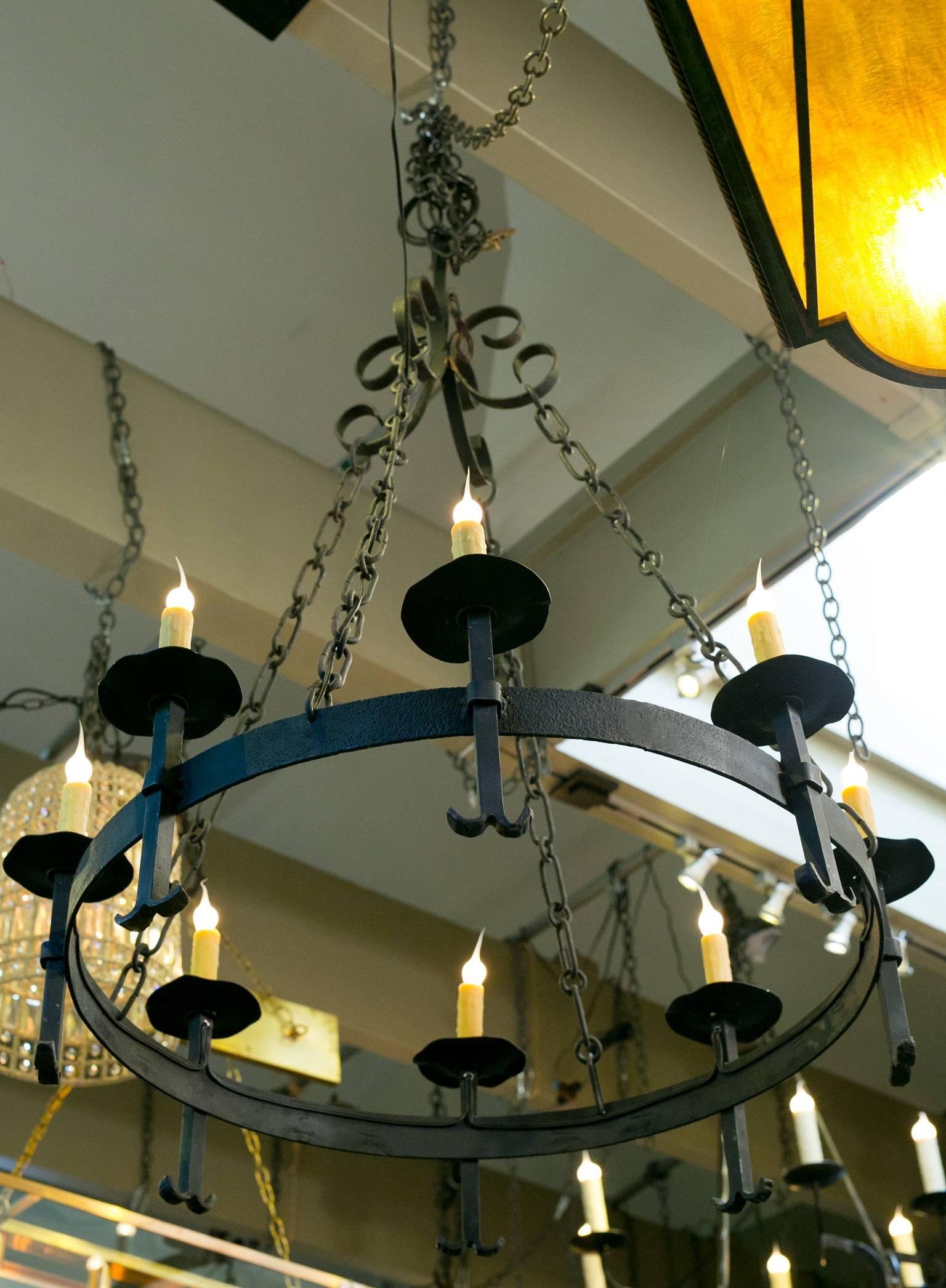 Vintage hand-forged iron chandelier from France, circa 1920. Newly rewired in the USA with all UL approved parts and eight candelabra sockets.  Has additional chain and a canopy. Height is (as shown) to the top of the loop above the metal scrolls