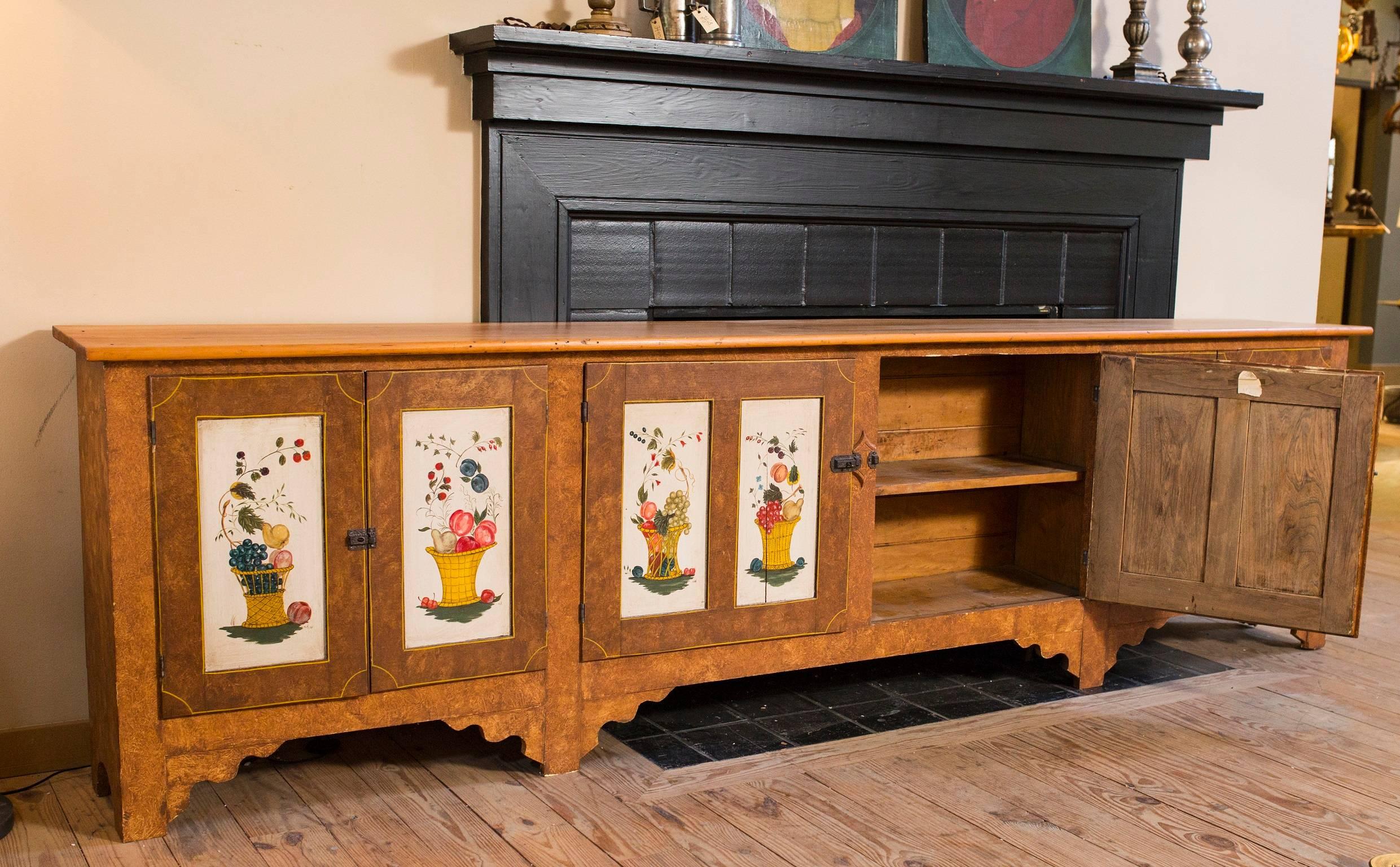 Faux wood grain painted on front and sides with fruit and floral basket theme on doors. Antique furniture piece. Commissioned and hand-painted by American artist Lew Hudnall. Signed and dated 1974. Middle section is wider inside than outermost