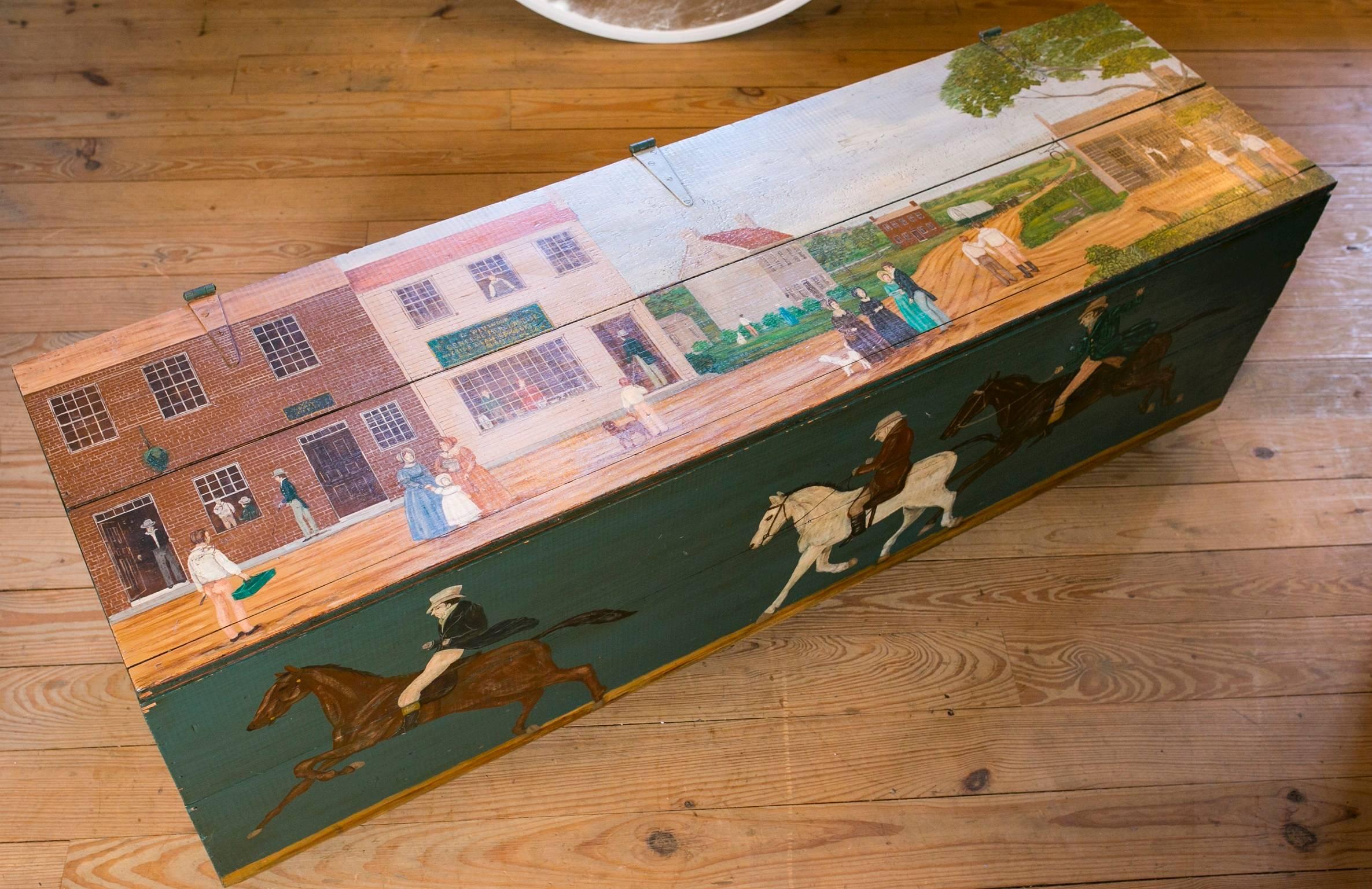 Wonderful large antique solid wood blanket chest with hinged top. Features a village scene on the top, men on horseback on the front, fruit imagery on the sides. Solid painted back. Antique chest, circa 1915, was hand-painted by American folk artist