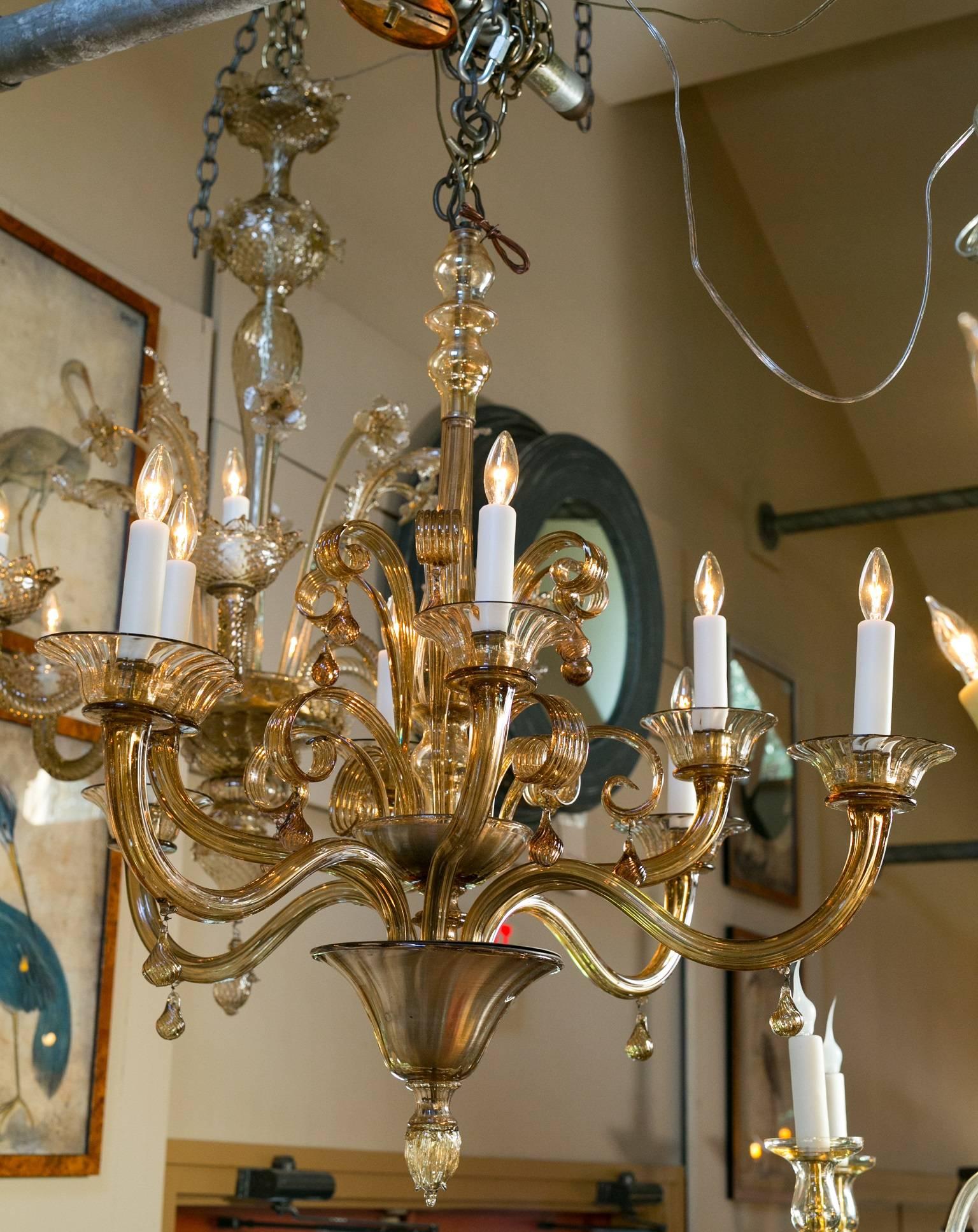 Large tea colored or amber Murano glass chandelier with glass scrolls and glass drops. Eight arms with candelabra sockets. Beautiful proportion and repetition. All original parts. Newly wired in the USA with all UL approved parts. Comes with chain