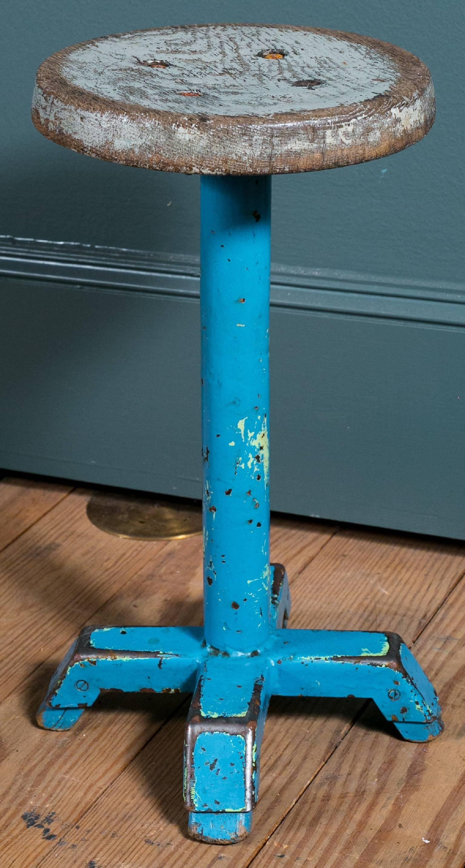 Charming painted iron stool with wooden seat from a Belgian school house. One blue available (red and green in photo have sold). Price is for one stool.  We have one green available with a newer wood top- not photographed.   Additional photos upon