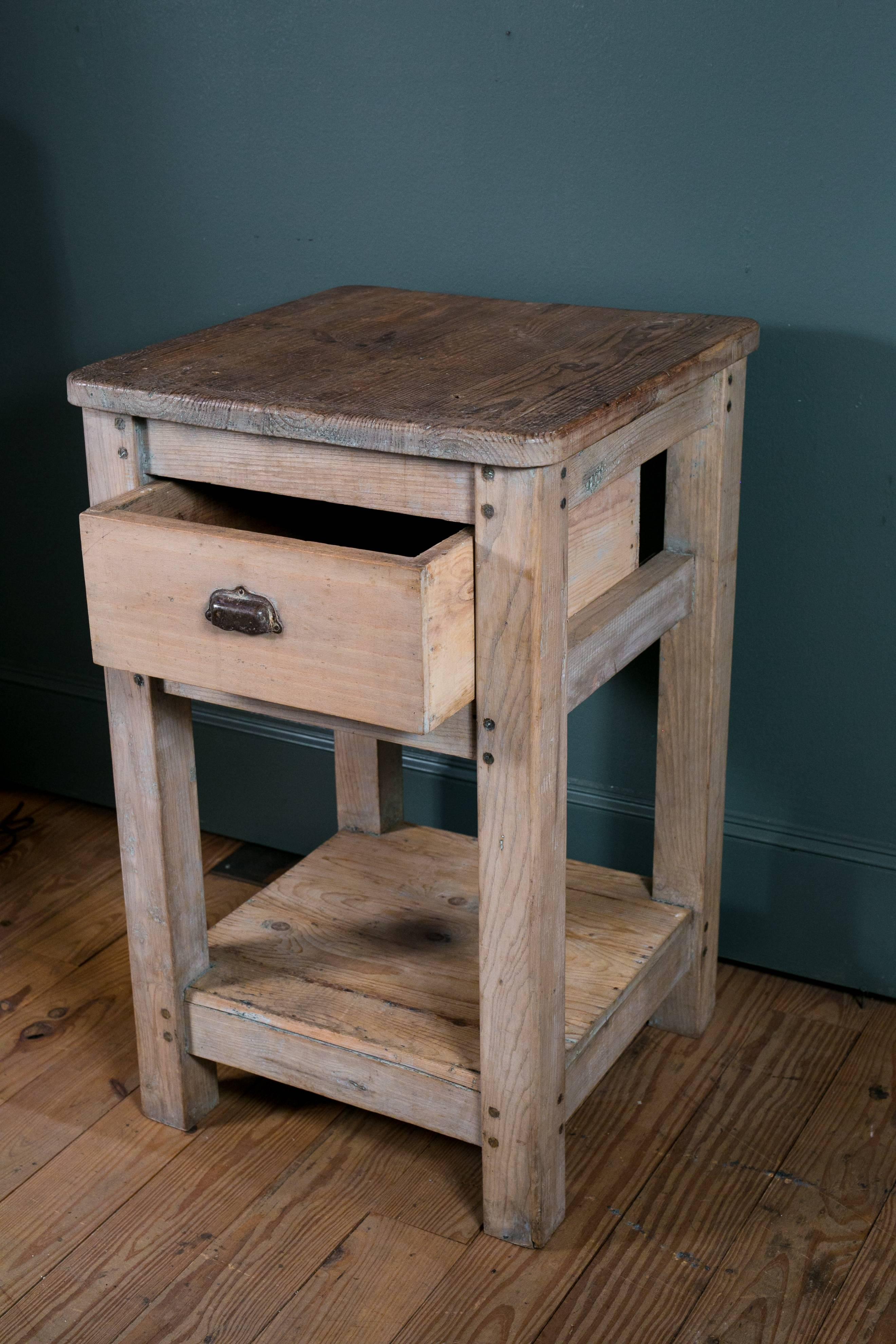 Wooden butcher block with drawer and shelf below for storage.
Original drawer pull.