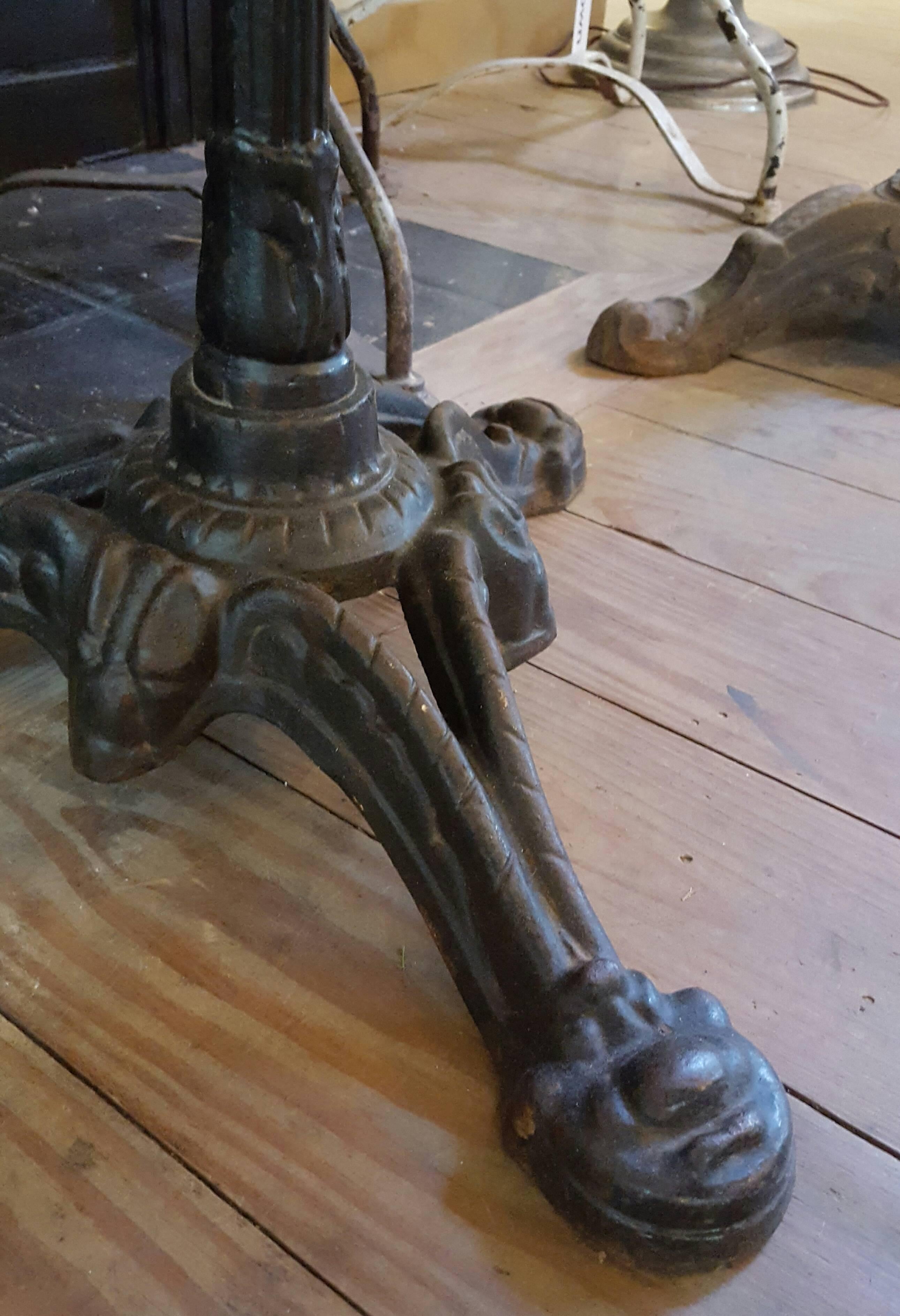 Antique French forged black iron bistro table base with raw edged honed marble top. Base is circa 1900, top is circa 1960.  Beautiful casting on the iron base.