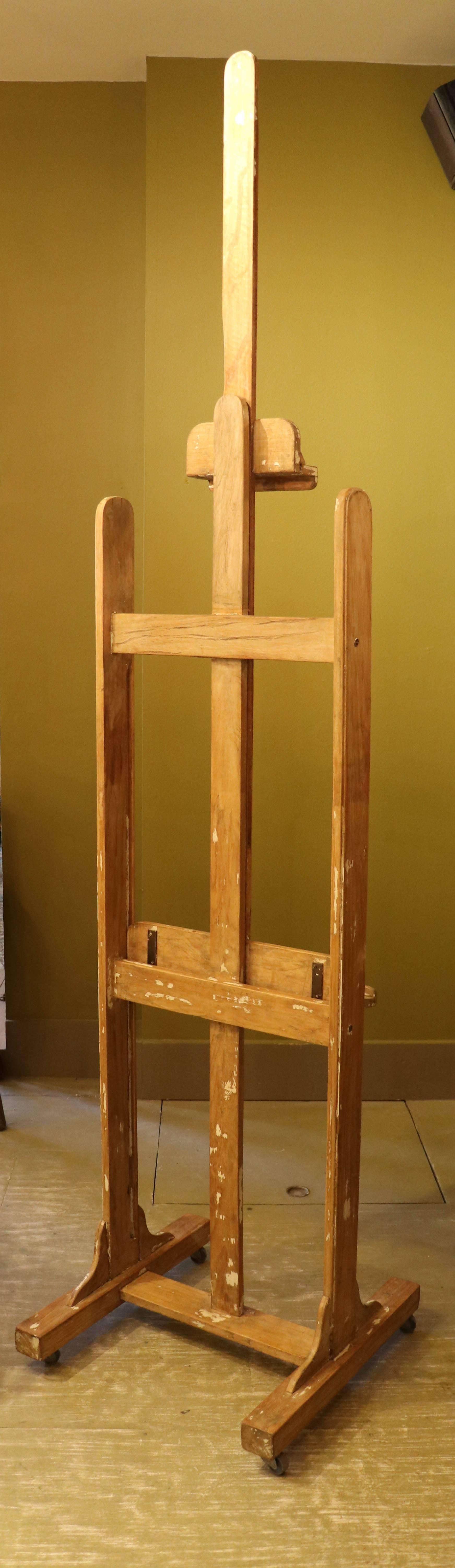 French artist's wooden easel on casters, circa 1940. Top support and bottom tray move up or down and are lockable. All original parts. Height listed is with tray all the way at the base.