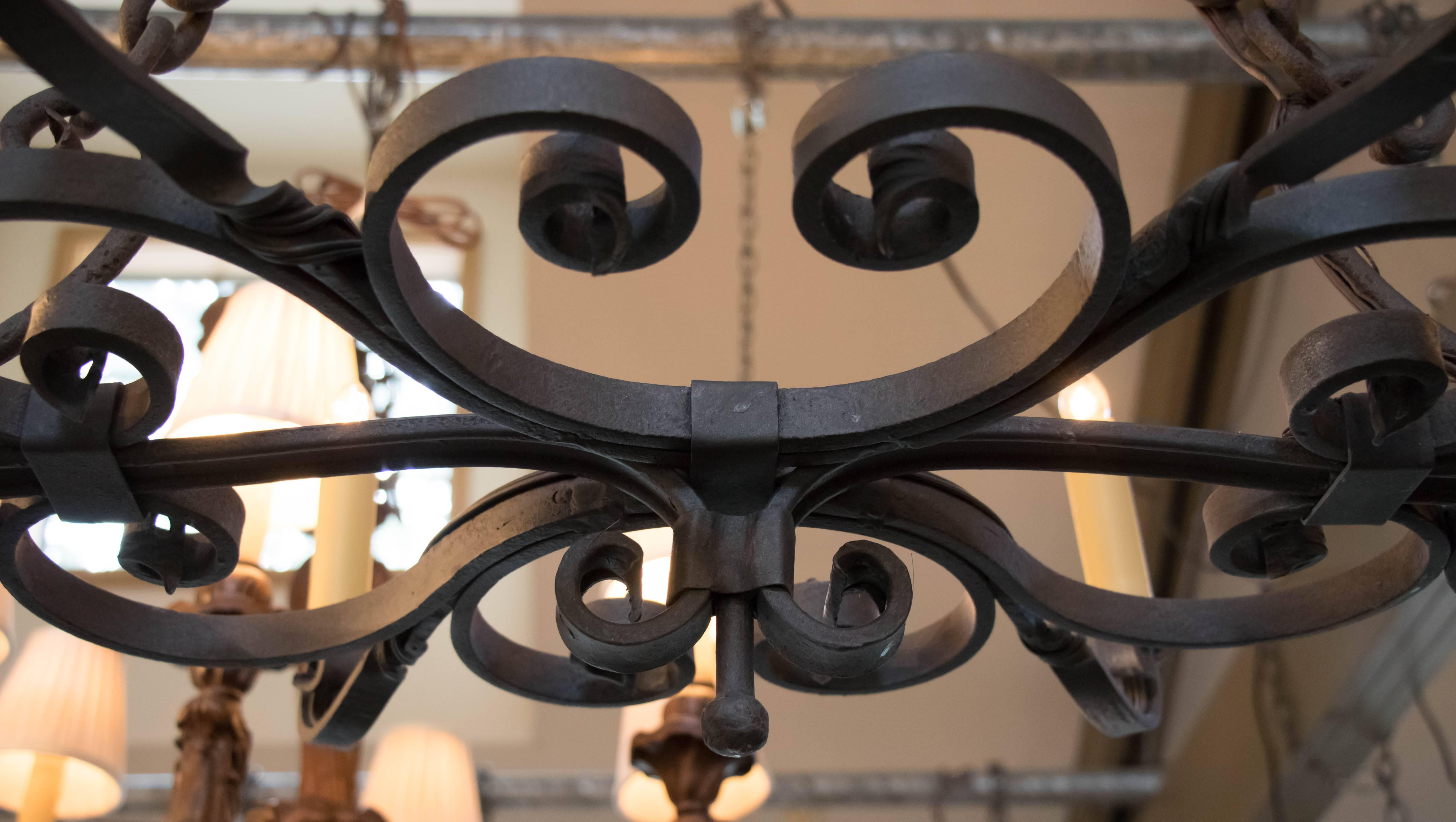 Heavy hand-forged east-west iron chandelier from Spain, circa 1930. Expert craftsmanship with wonderful attention to detail on the ironwork. Newly wired in the US with all UL listed parts and six candelabra sockets. Would be great over a kitchen