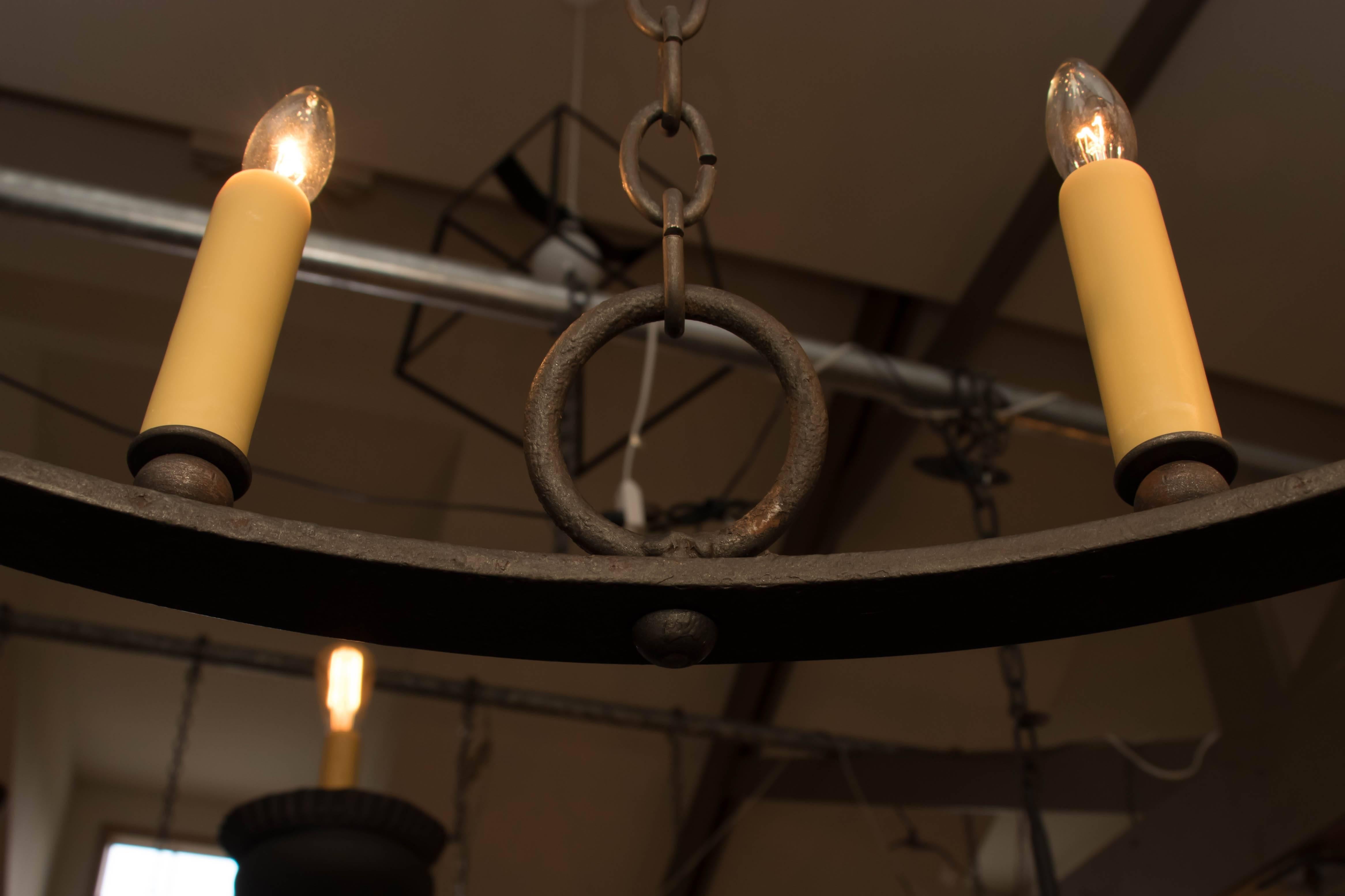 One of a kind, hand-forged vintage iron ring chandelier with eight candelabra sockets. Four chains connect to handcrafted iron loops on the body and go up to a handmade custom iron canopy with four hooks. Newly wired with UL listed parts. Height is