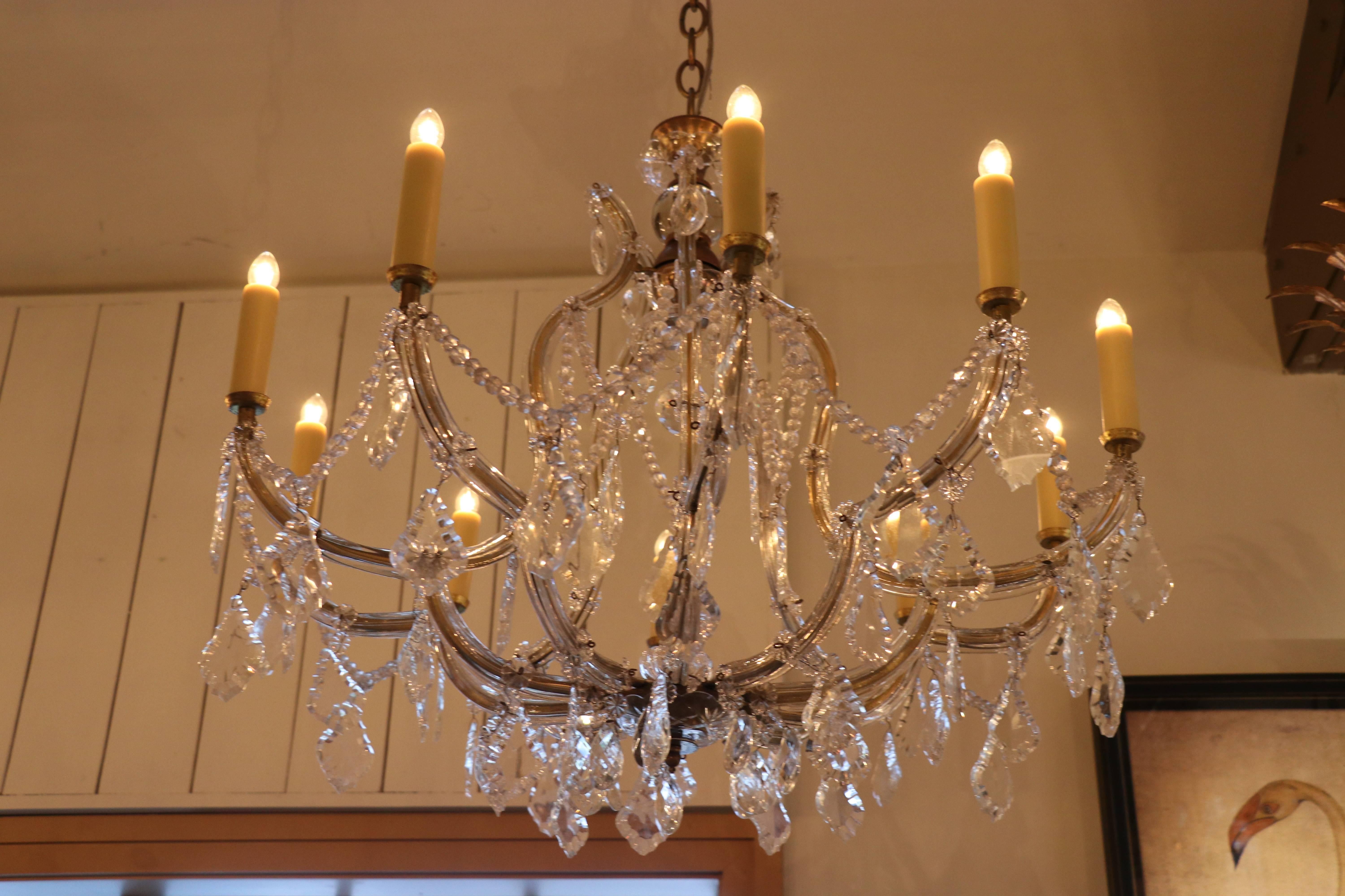Crystal Maria Theresa style chandelier from France. Newly wired with all UL listed parts and ten candelabra sockets. Aged brass cage with flat pieces of glass on the body and clear glass rosettes. Clear crystals at the top and bottom with crystal