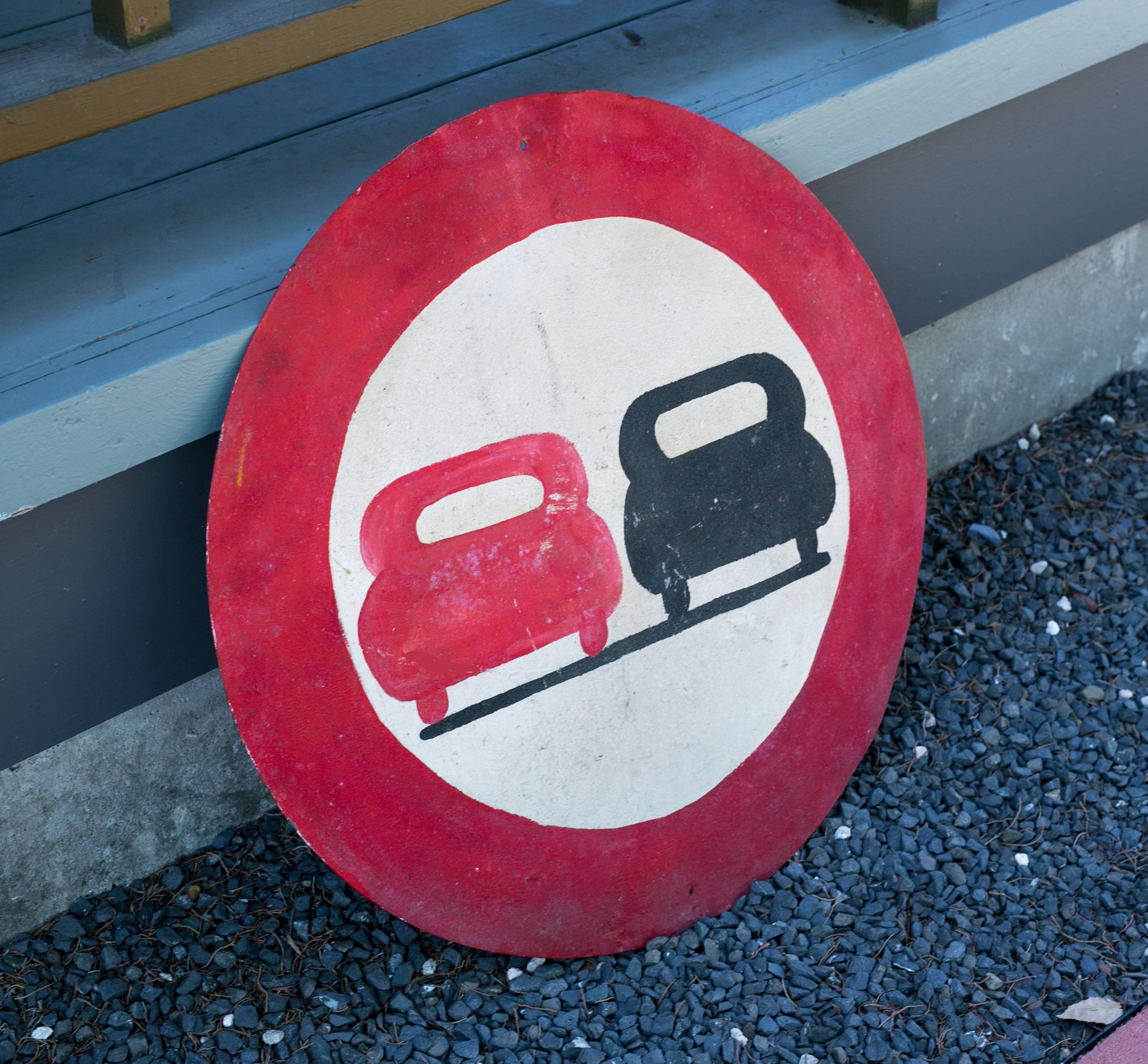 Charming and highly graphic two-car road safety sign from France, circa 1930. Hand-painted on metal with black, red and white paint. Has a hole at the top and bottom from which it can be hung.