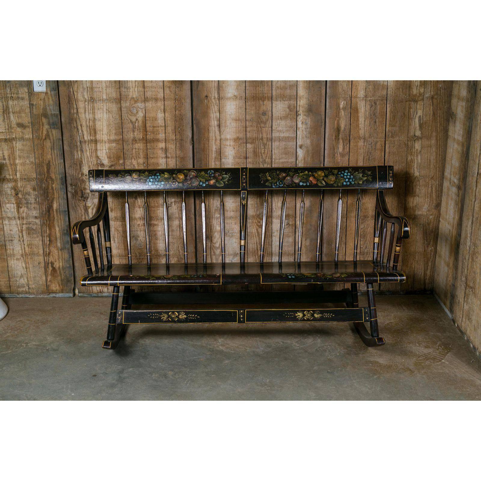 American wooden rocking bench in the Hitchcock style, circa 1890s. Designed to be a cradle rocker combination to cradle and rock your baby to sleep. There is a slat that can be raised to keep the baby in place. The painting was added in the 20th
