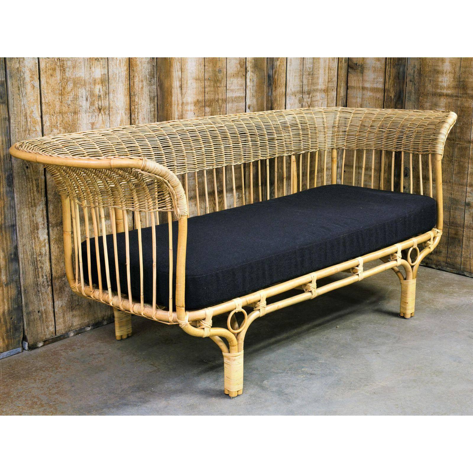 Woven rattan sofa, originally designed by Franco Albini in 1951. New construction for indoor use with new upholstered cushion in a dark greyish-black woven fabric. A classic and iconic design. Measure: Seat height listed is including cushion, frame
