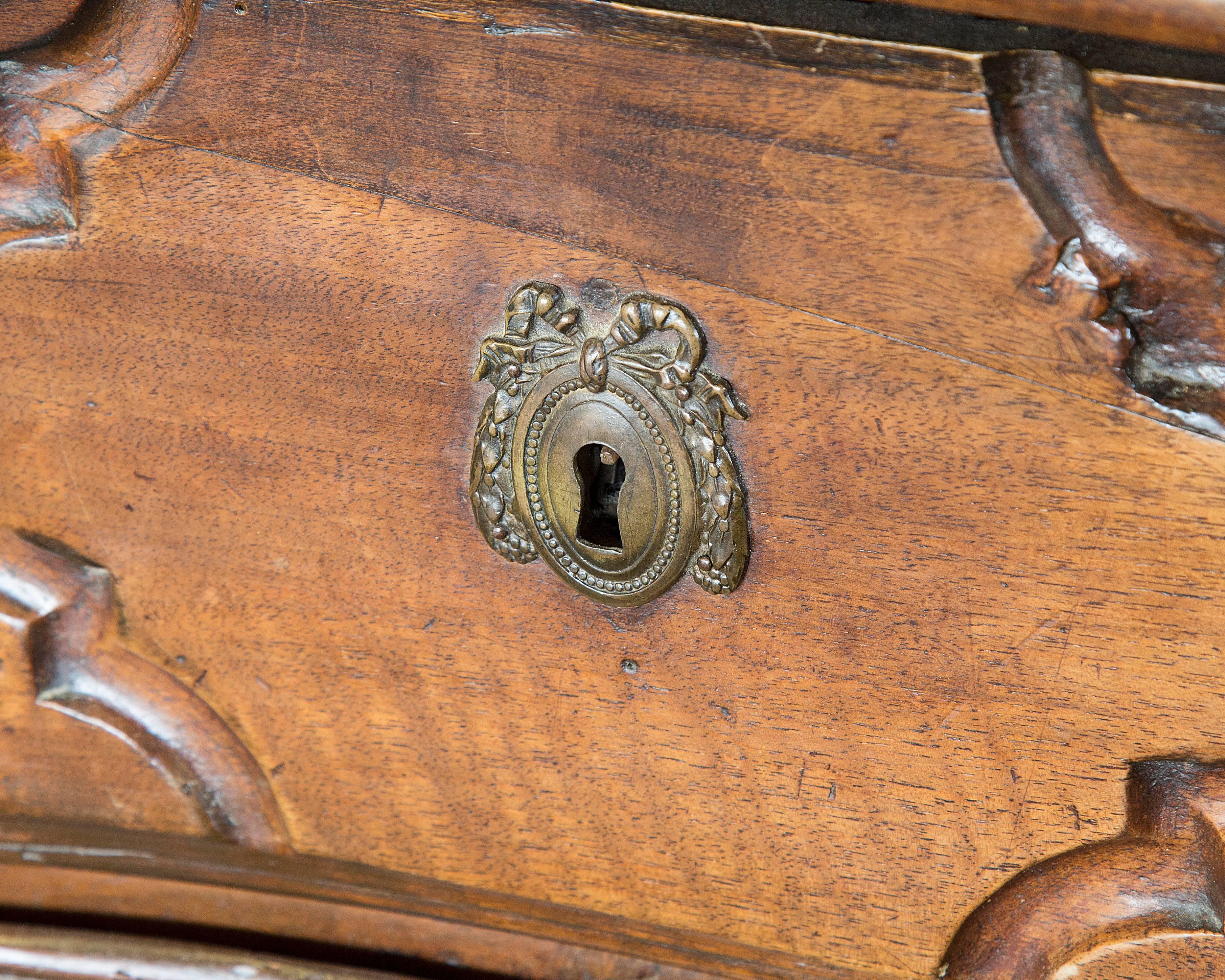18th century five-drawer commode with shapely front and heavily carved drawer fronts, original hardware.
 