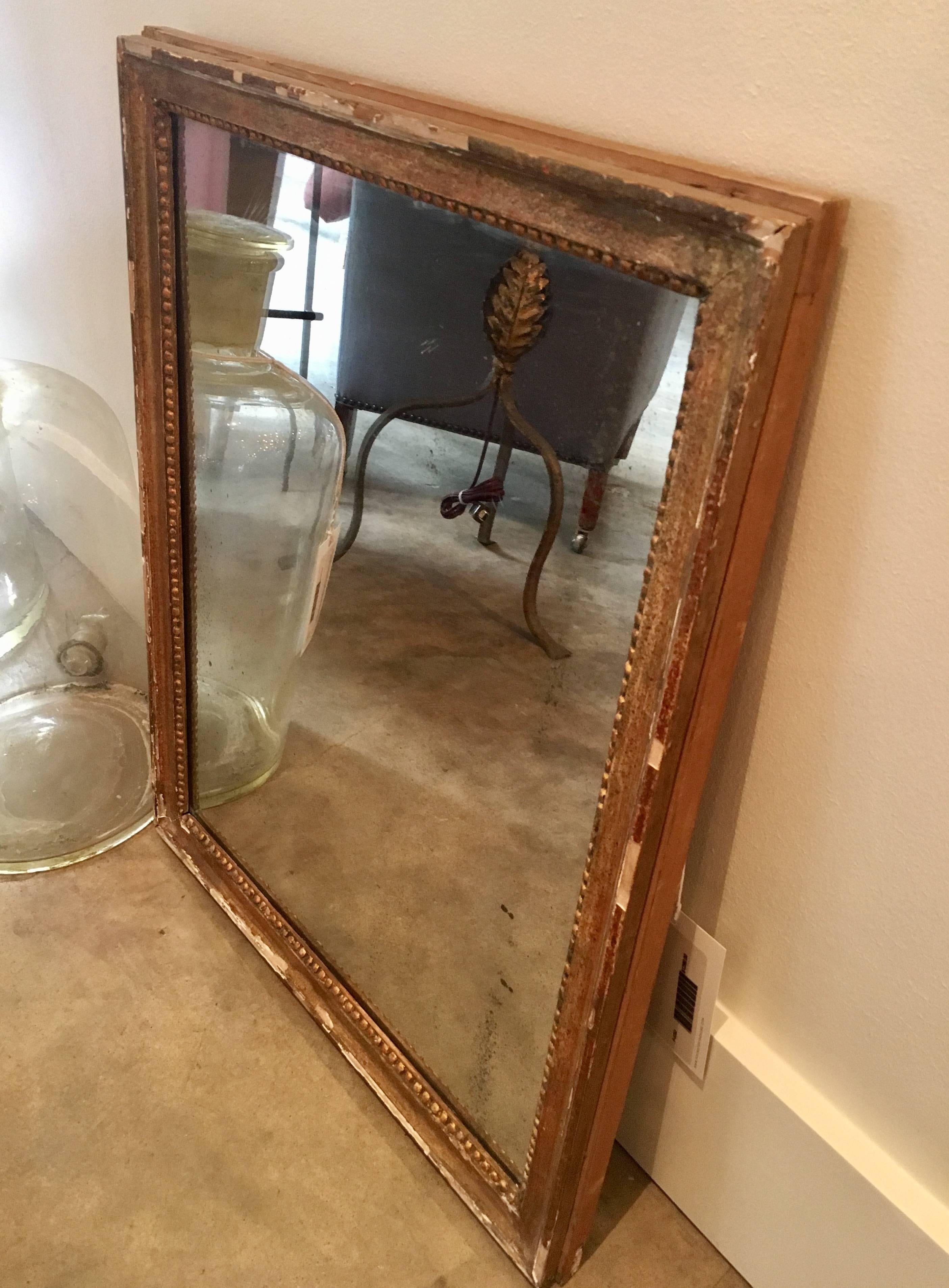 Petite 19th century mirror with giltwood bead frame, original plate. Dimensions: 20.5” W x 1.5” D x 26” H.