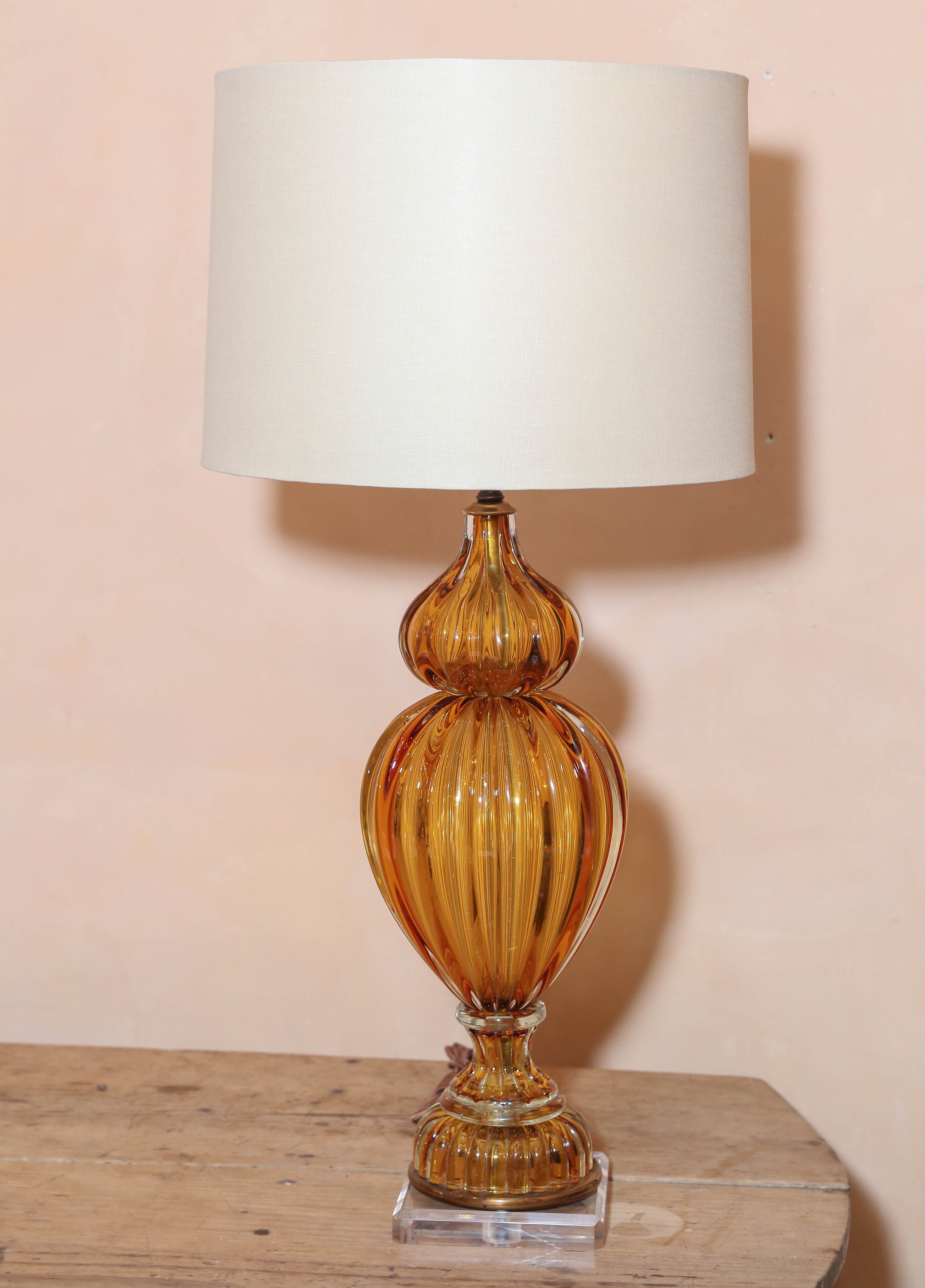 Murano amber color glass lamp by Marbro. Mid-Century Modern blown glass lamp made for Marbro Lamp Company, circa 1960. Updated with Lucite base and a complementary linen shade (measurements include shade). Newly wired for use within the USA.



 