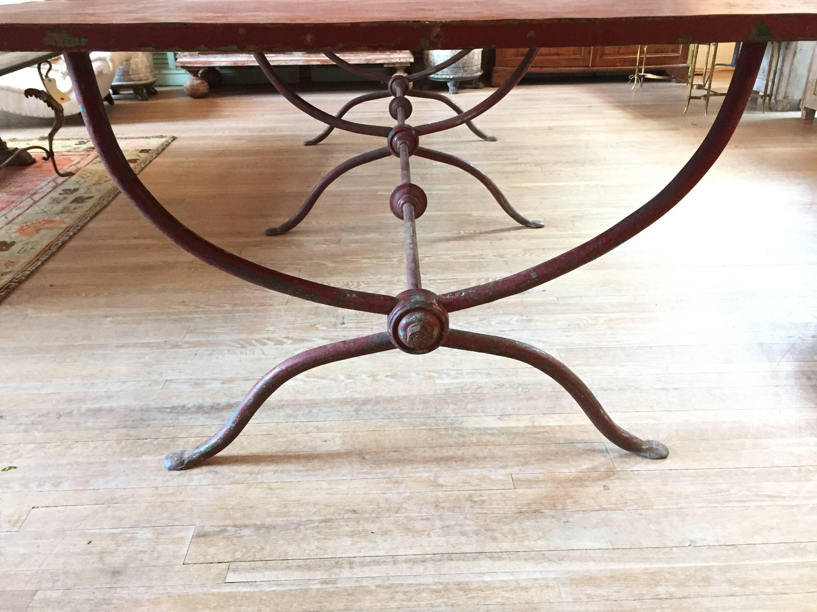 Handsome and large 19th century Italian garden table. Three sets of curved legs connected by iron rods with decorative rondels. Top braded in place. Great patina.
