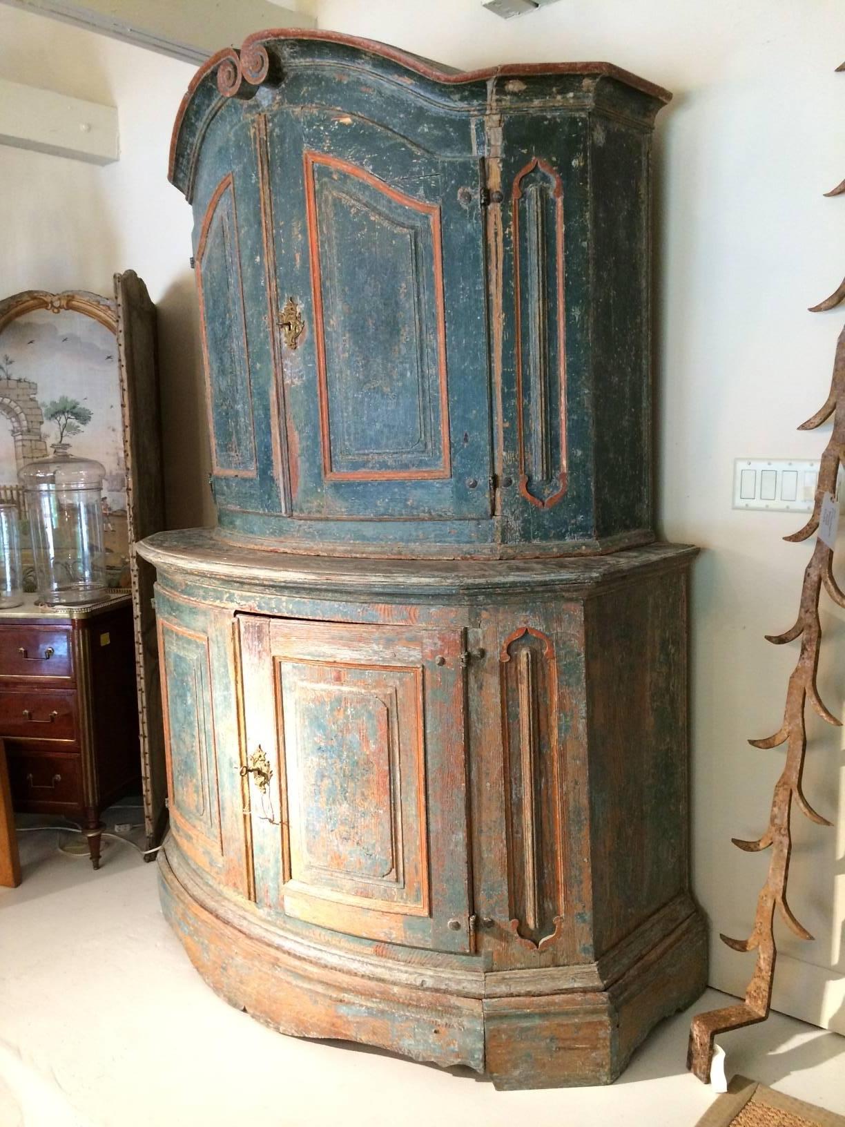 Large 18th century Swedish cabinet in three parts. Base has a hidden drawer, bottom cabinet with two curved doors and interior shelf. Upper cabinet two doors with shelf and spoon hanger shelf. Original gilt hardware and keys.
